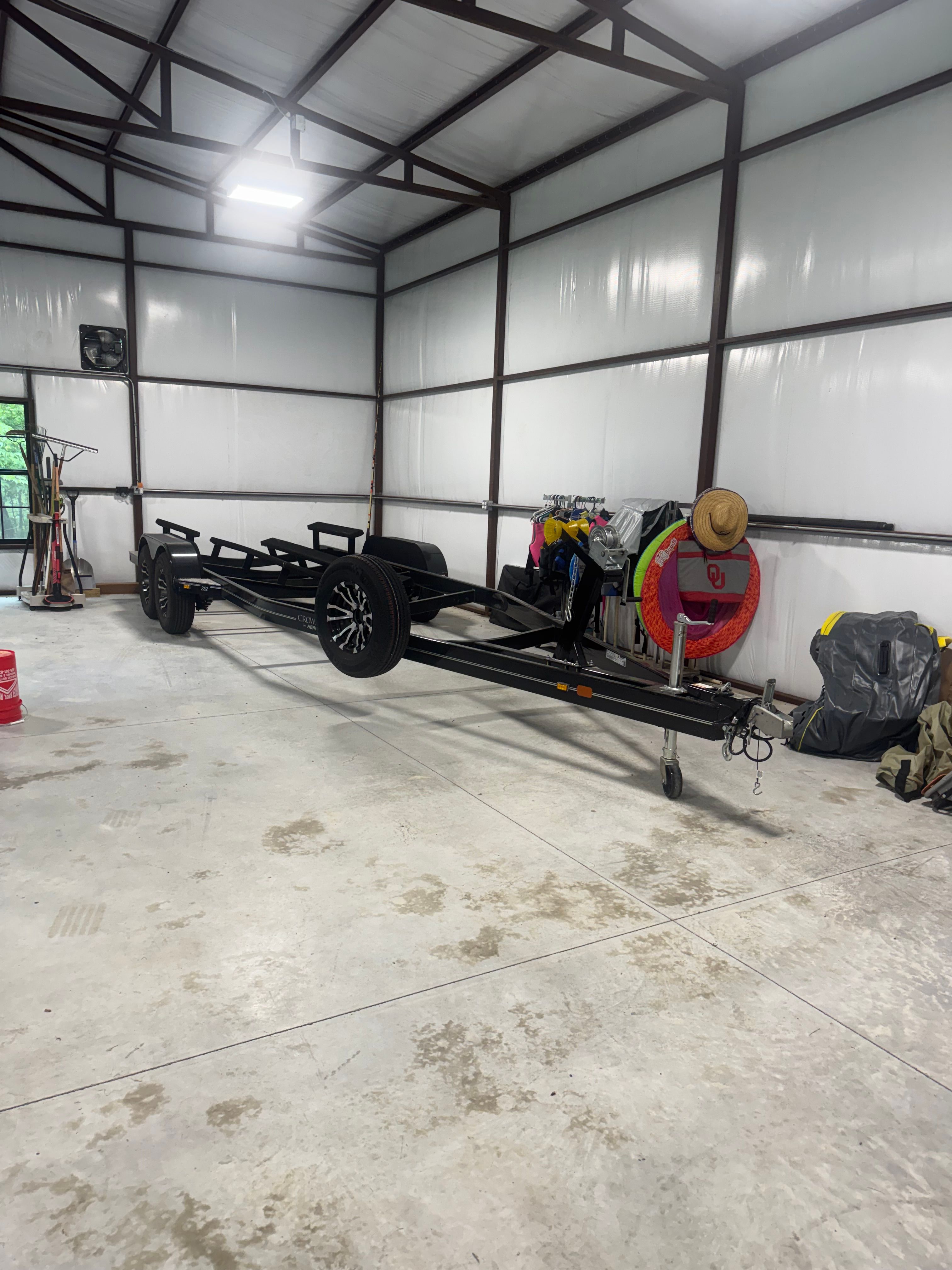 An empty boat trailer in a large garage.