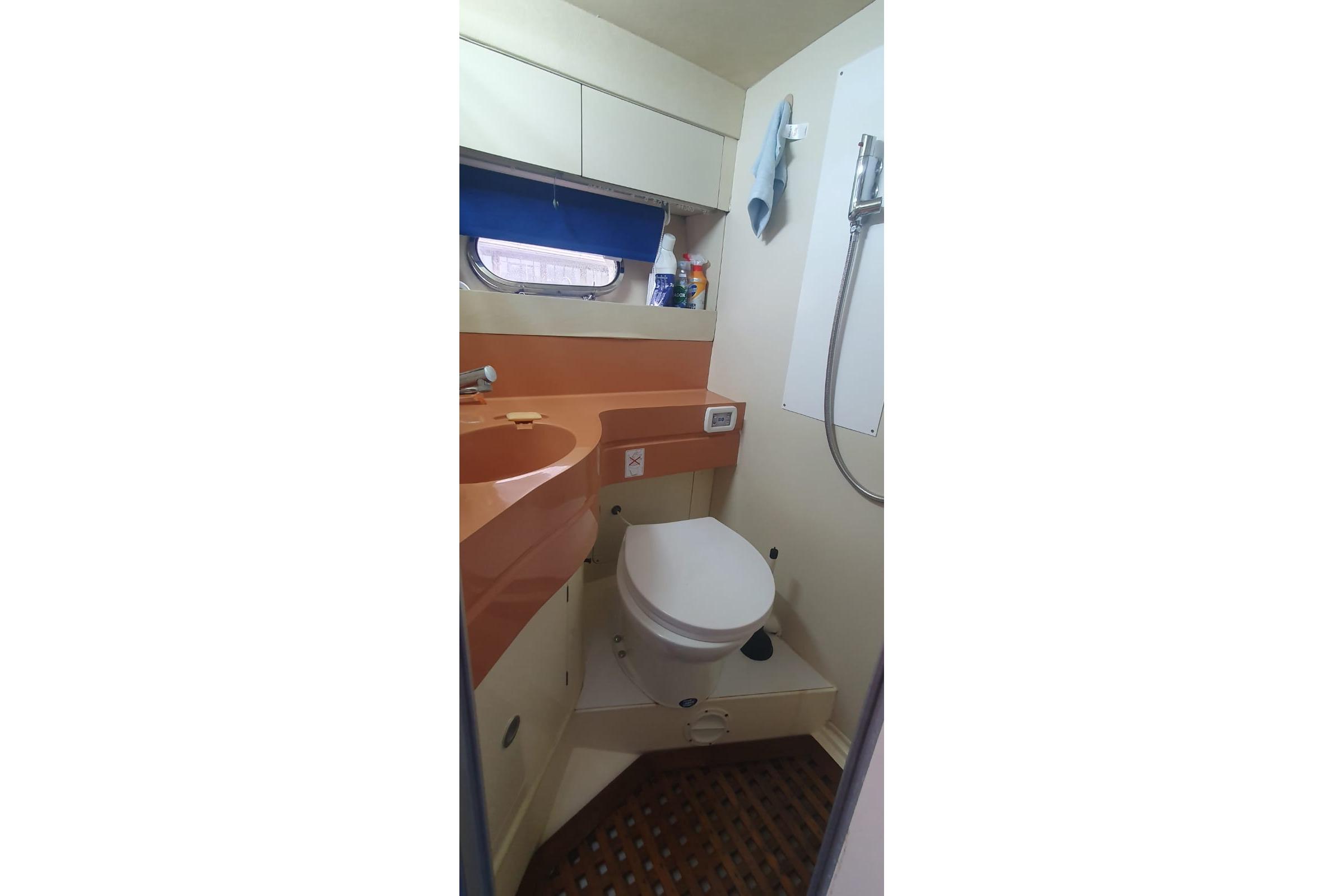 Compact bathroom in a 1989 Princess 35 boat, featuring a toilet and sink.