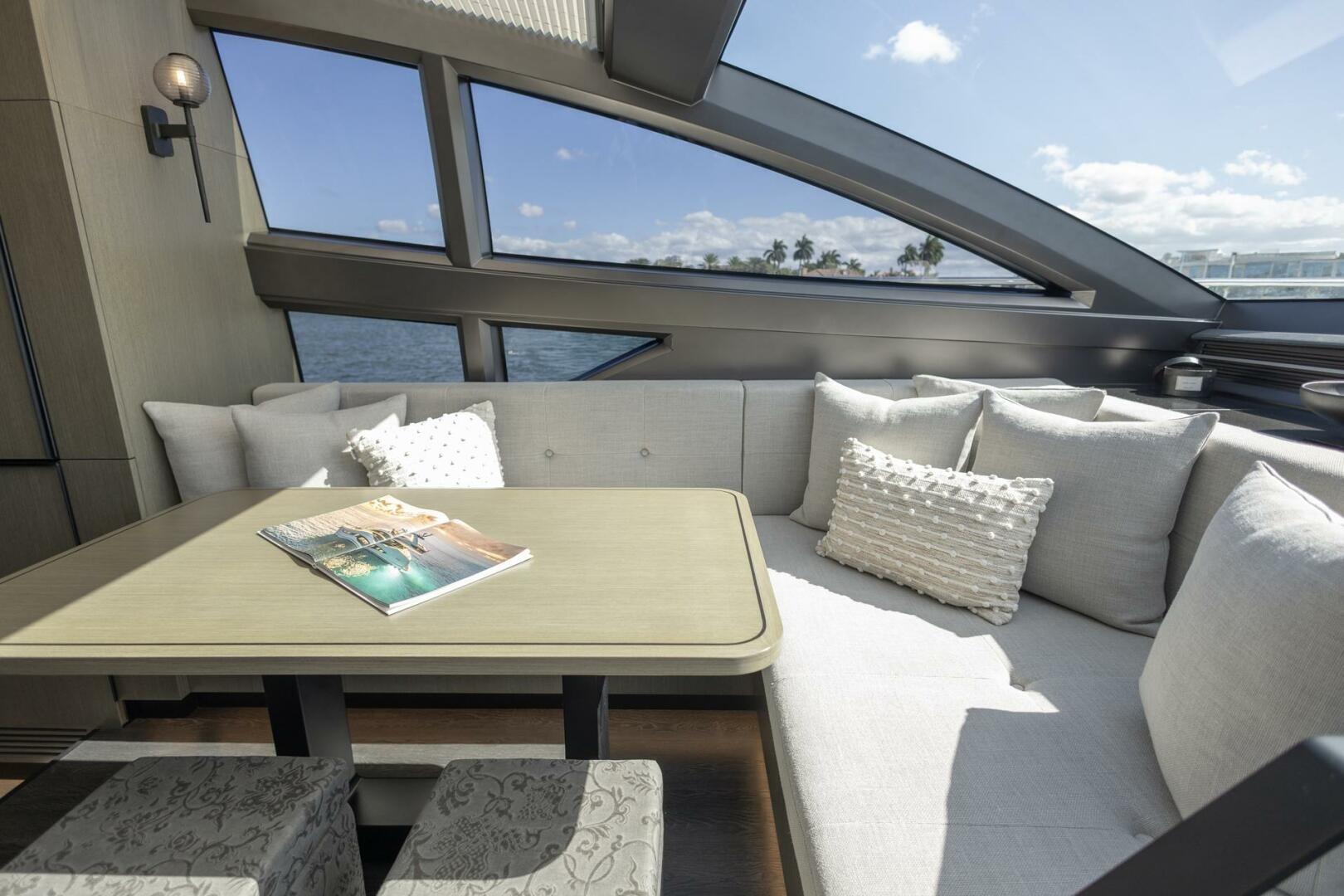 Luxurious interior of 2023 Pearl 72 yacht with elegant seating and scenic ocean view.