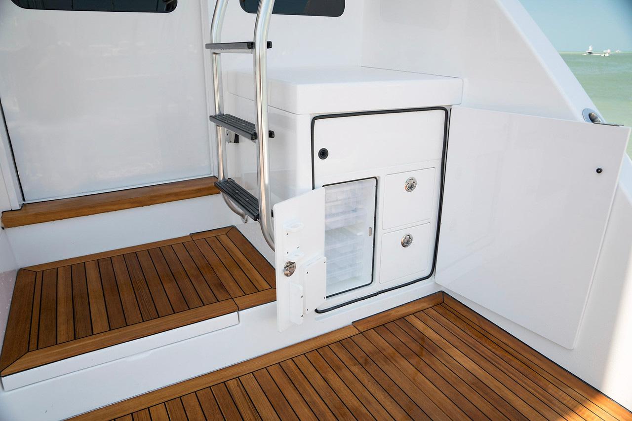 Manufacturer Provided Image: 2026 Bertram 61 Convertible yacht interior with wooden flooring and storage compartments.