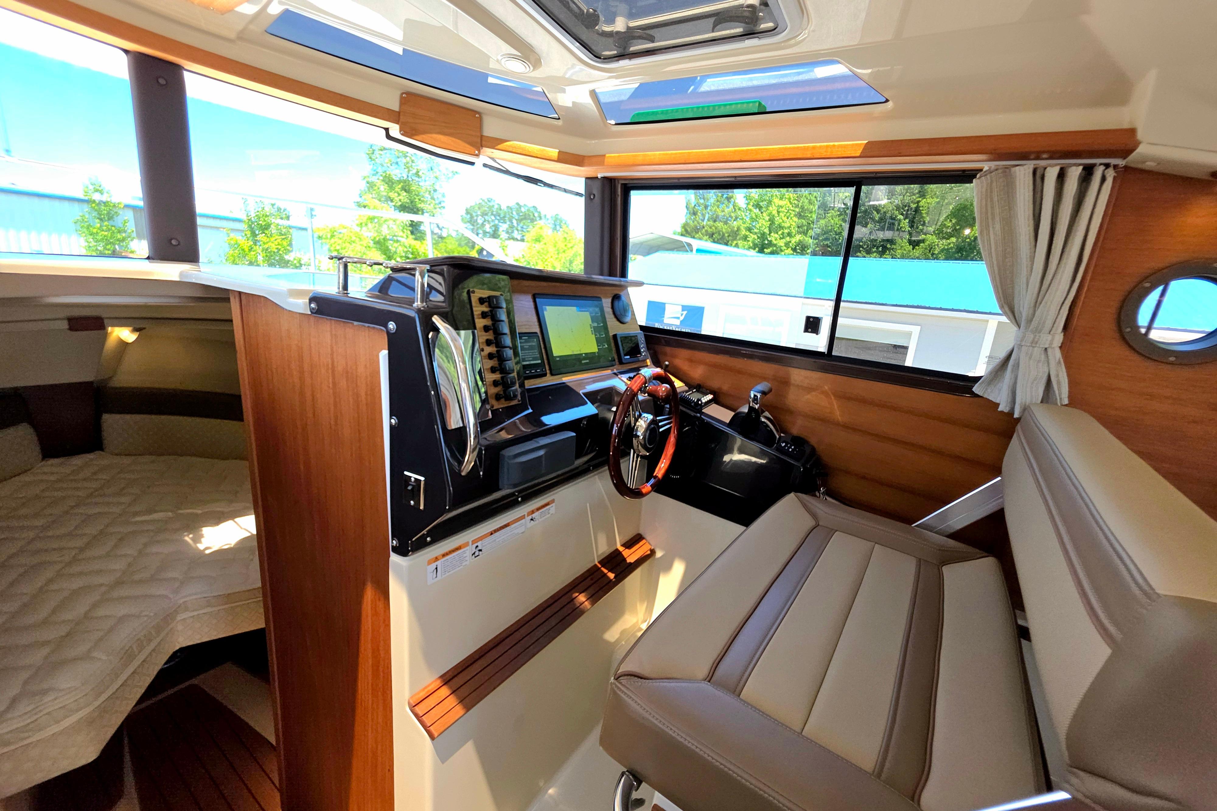 Interior of 2021 Ranger Tug R27 boat with helm, seating, and cabin view.