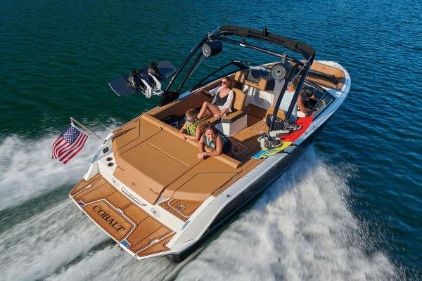Manufacturer Provided Image: 2025 Cobalt CS23 boat cruising with passengers on a sunny day, American flag waving.