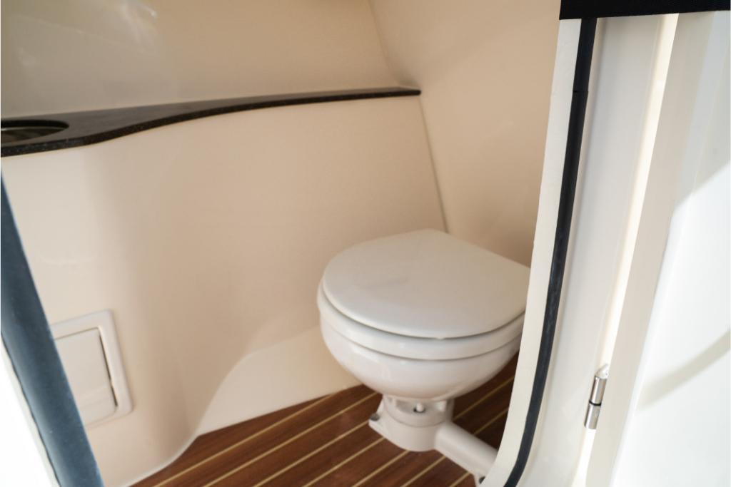 2023 Scout 240 Dorado boat interior with compact marine toilet.