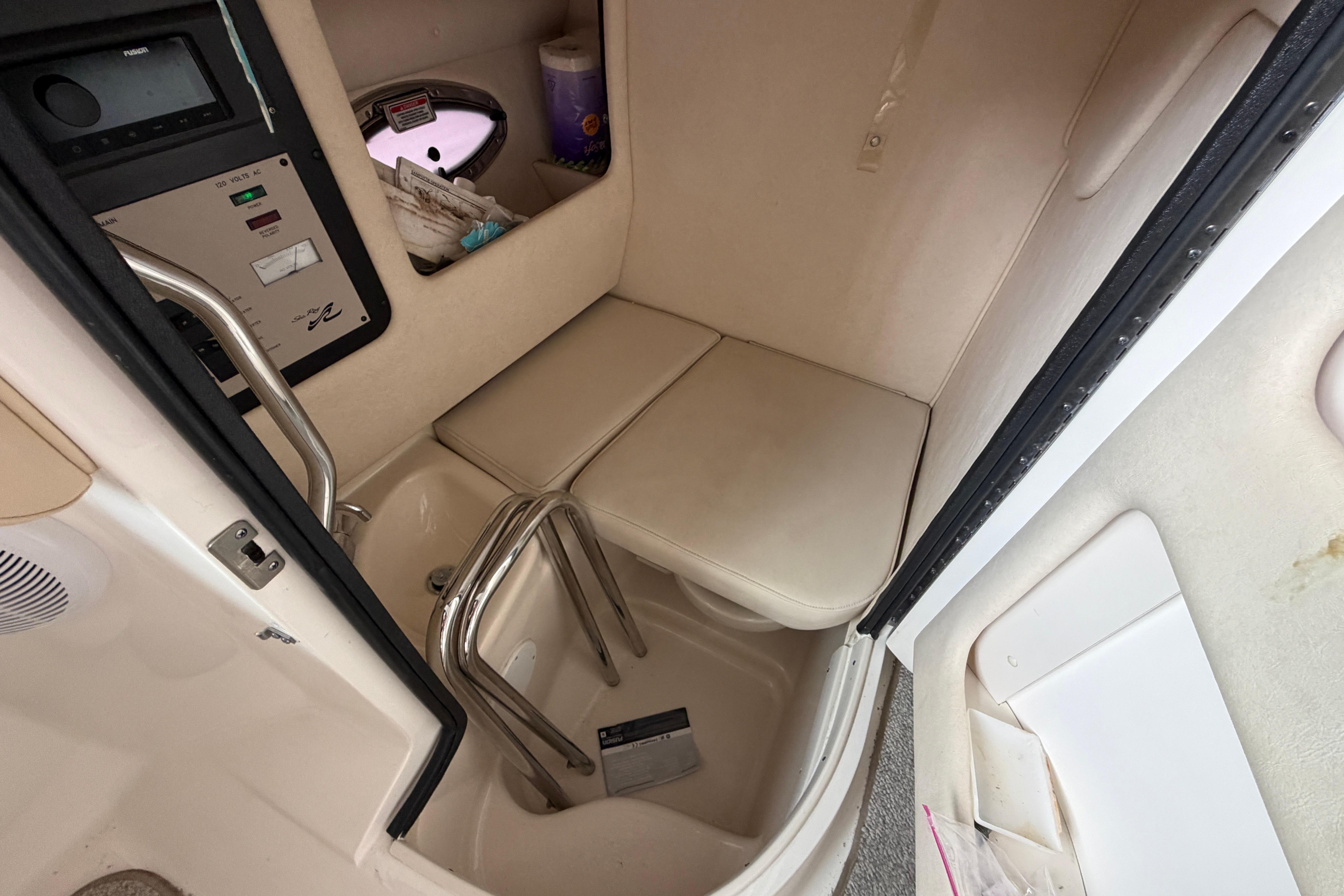 Interior cabin of 2003 Sea Ray 290 Bowrider boat with seating and control panel.