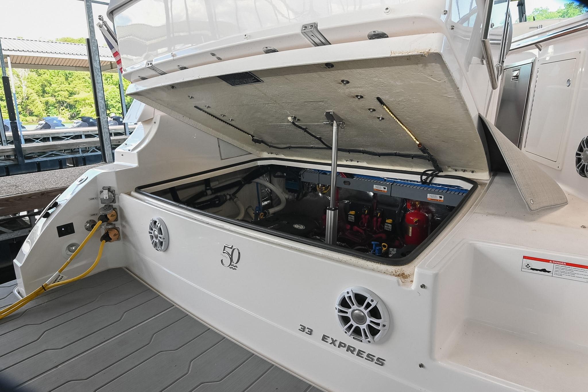 2021 Regal 33 Express boat engine compartment open, showcasing interior components and docked setting.