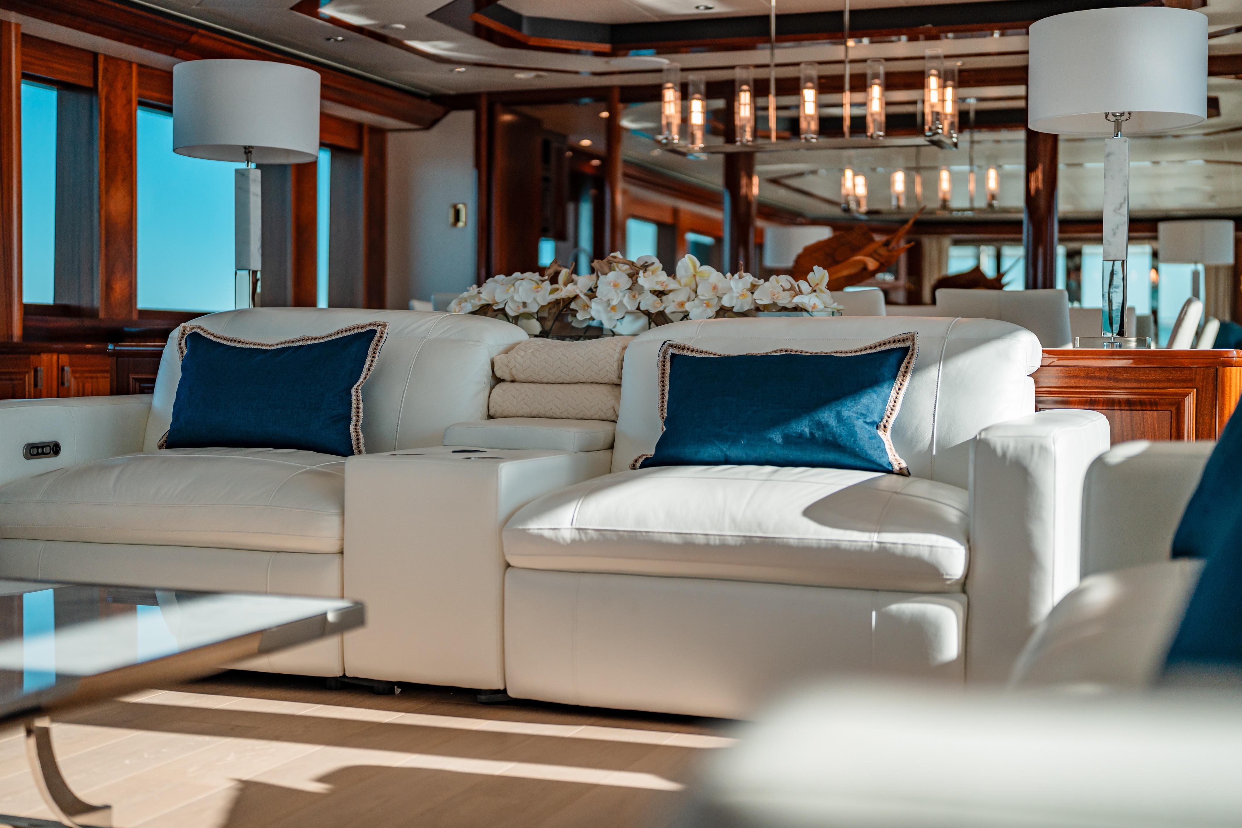 Luxurious interior of 2009 Westport Tri-Deck yacht with elegant white seating and blue cushions.