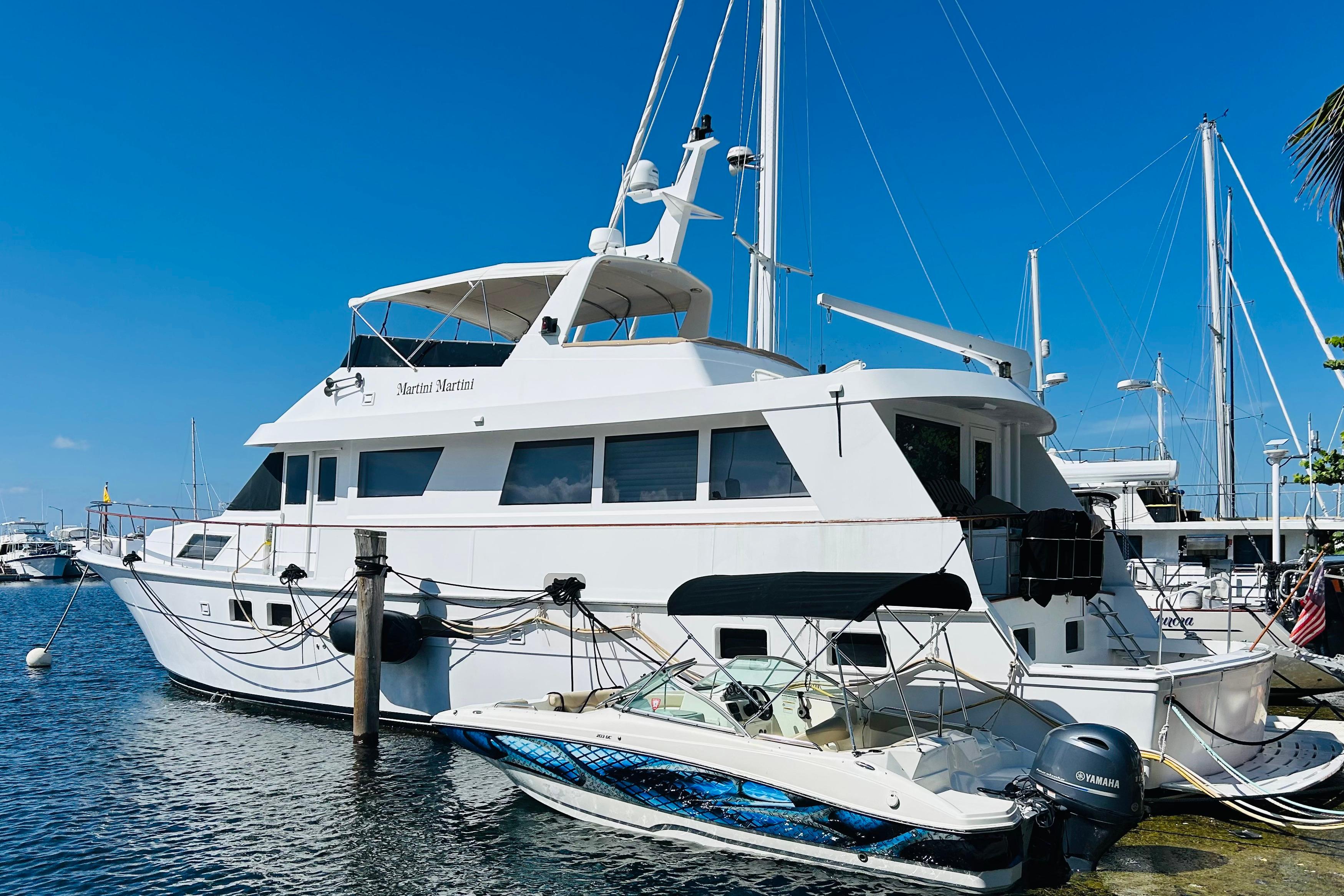 1991 Hatteras 70 Cockpit Motor Yacht docked in a sunny marina.