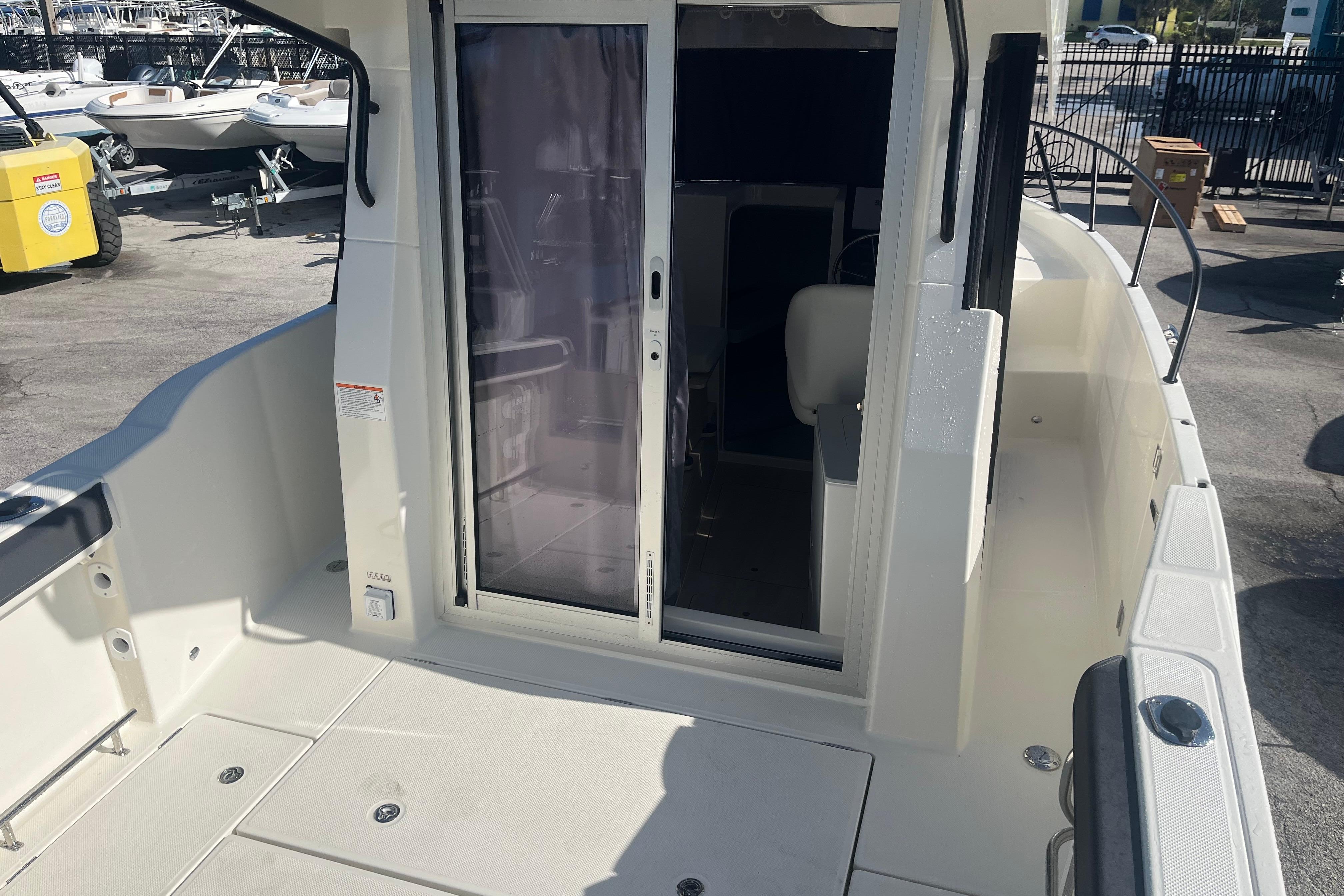 2025 Bayliner Trophy T25 Pilothouse boat deck with sliding door and seating area.