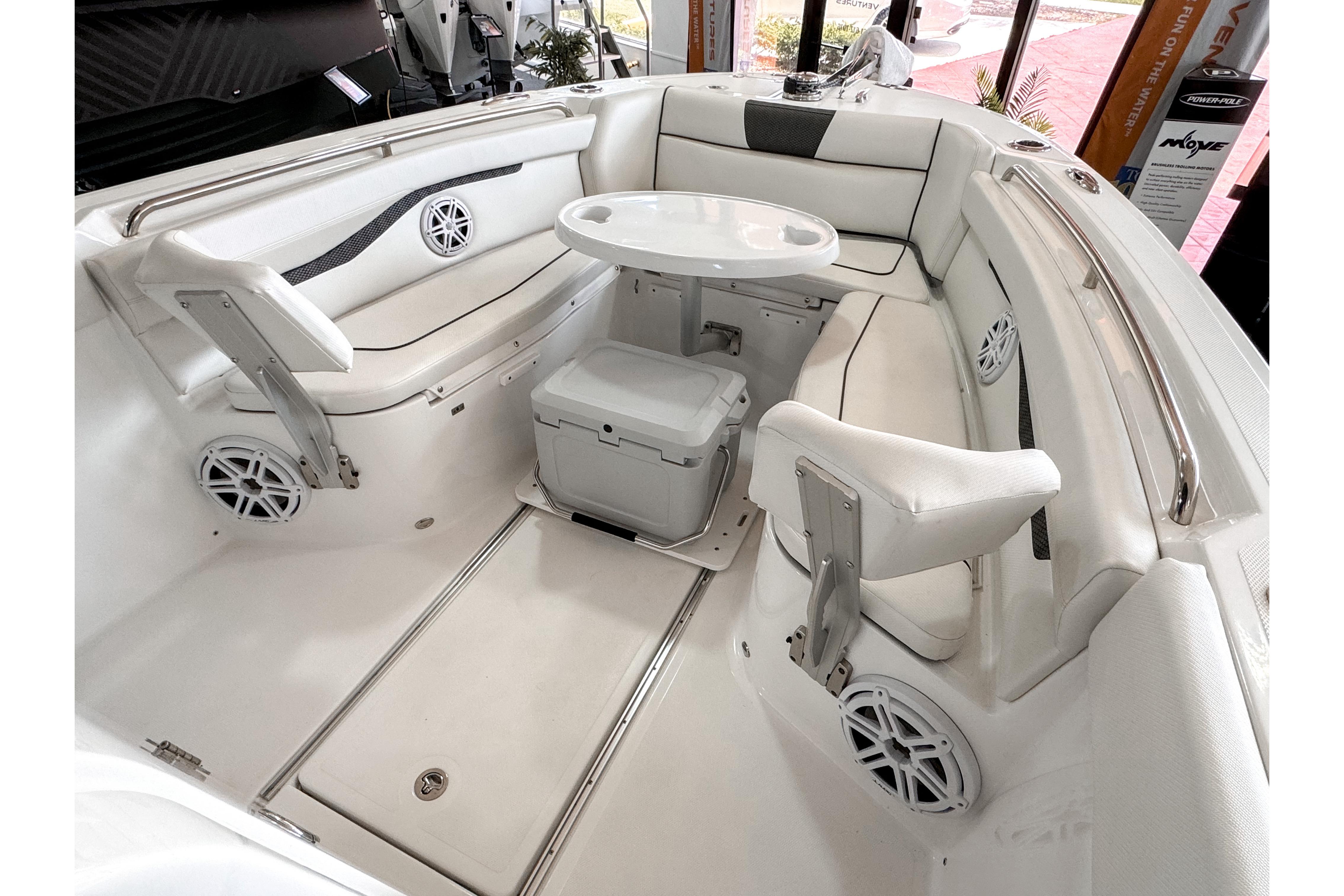 2024 Wellcraft 263 Fisherman boat interior with seating, table, and speakers.