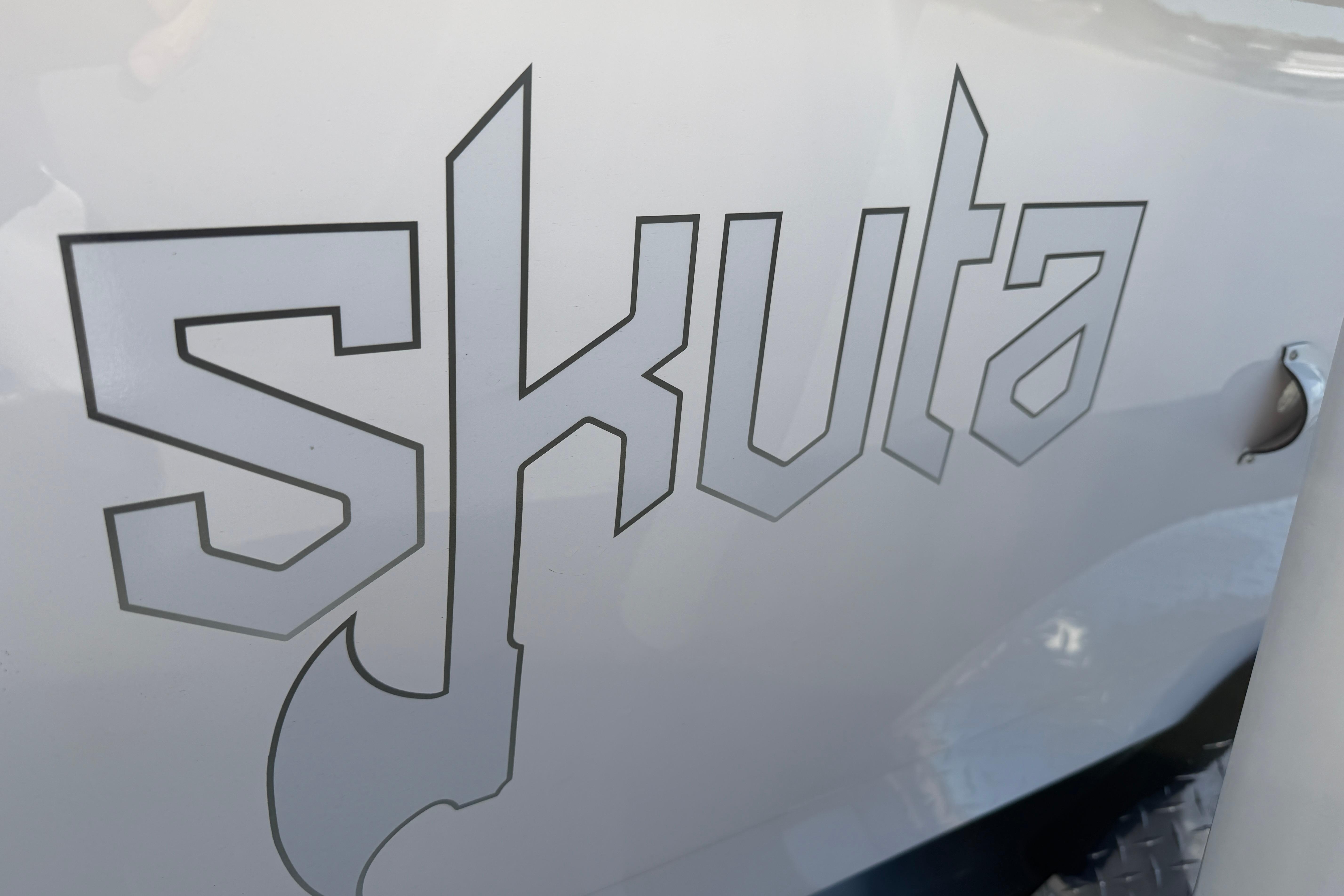 Skuta 24 Cat 2026 logo on vehicle exterior, featuring bold, angular typography.