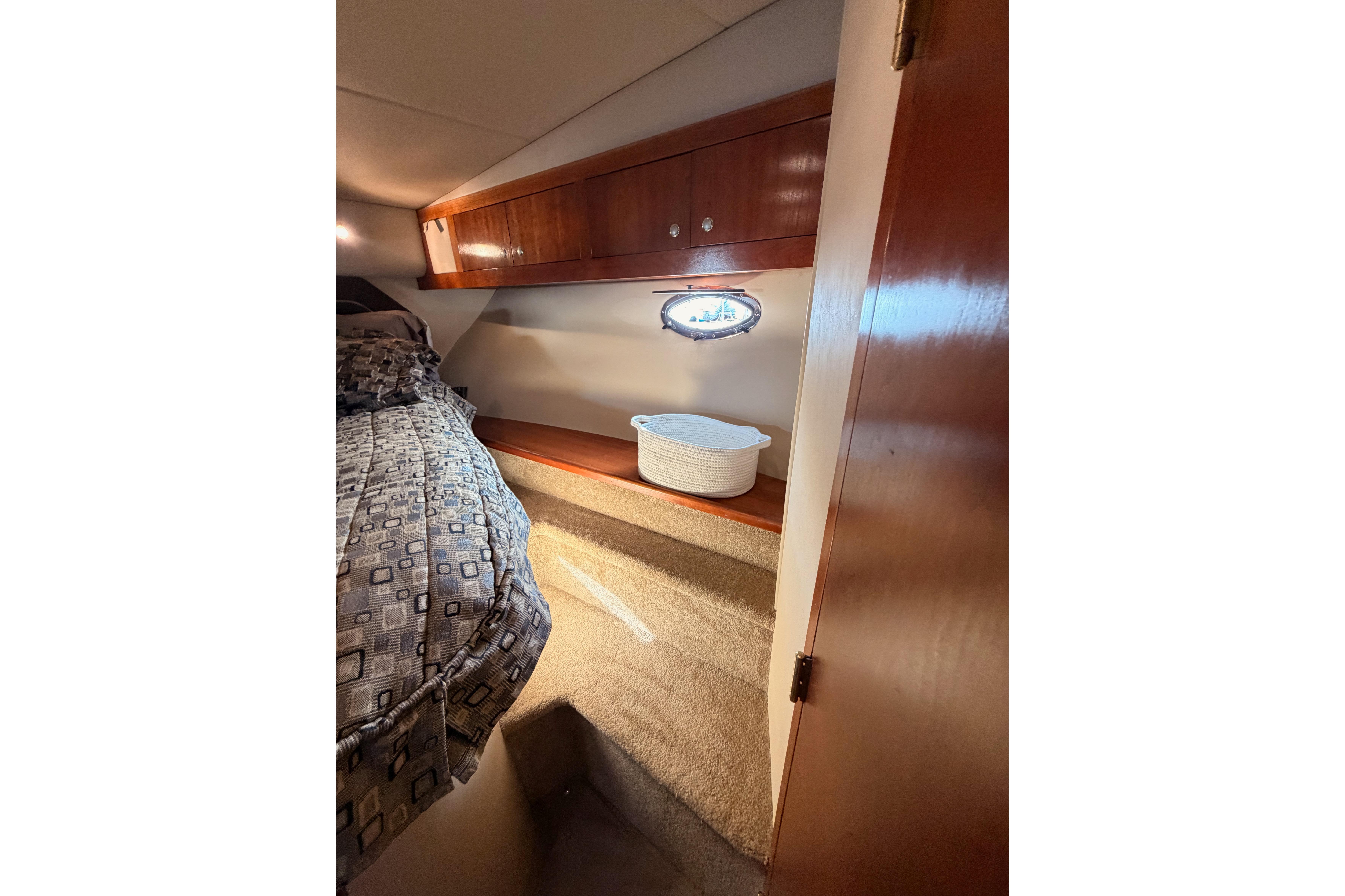 2005 Cruisers Yachts 405 Express Motoryacht cabin interior with bed and wooden cabinetry.