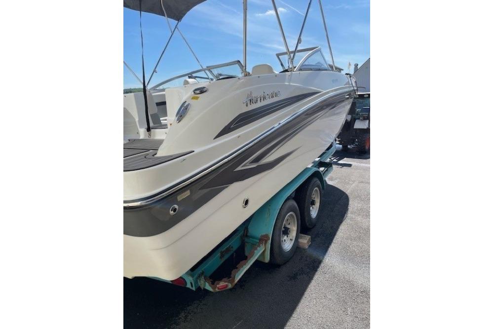 2023 Hurricane SunDeck 217 OB boat on trailer, parked outdoors under clear sky.