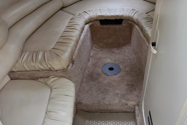 1999 Sea Ray 280 SS cabin interior with beige seating and carpeted flooring.
