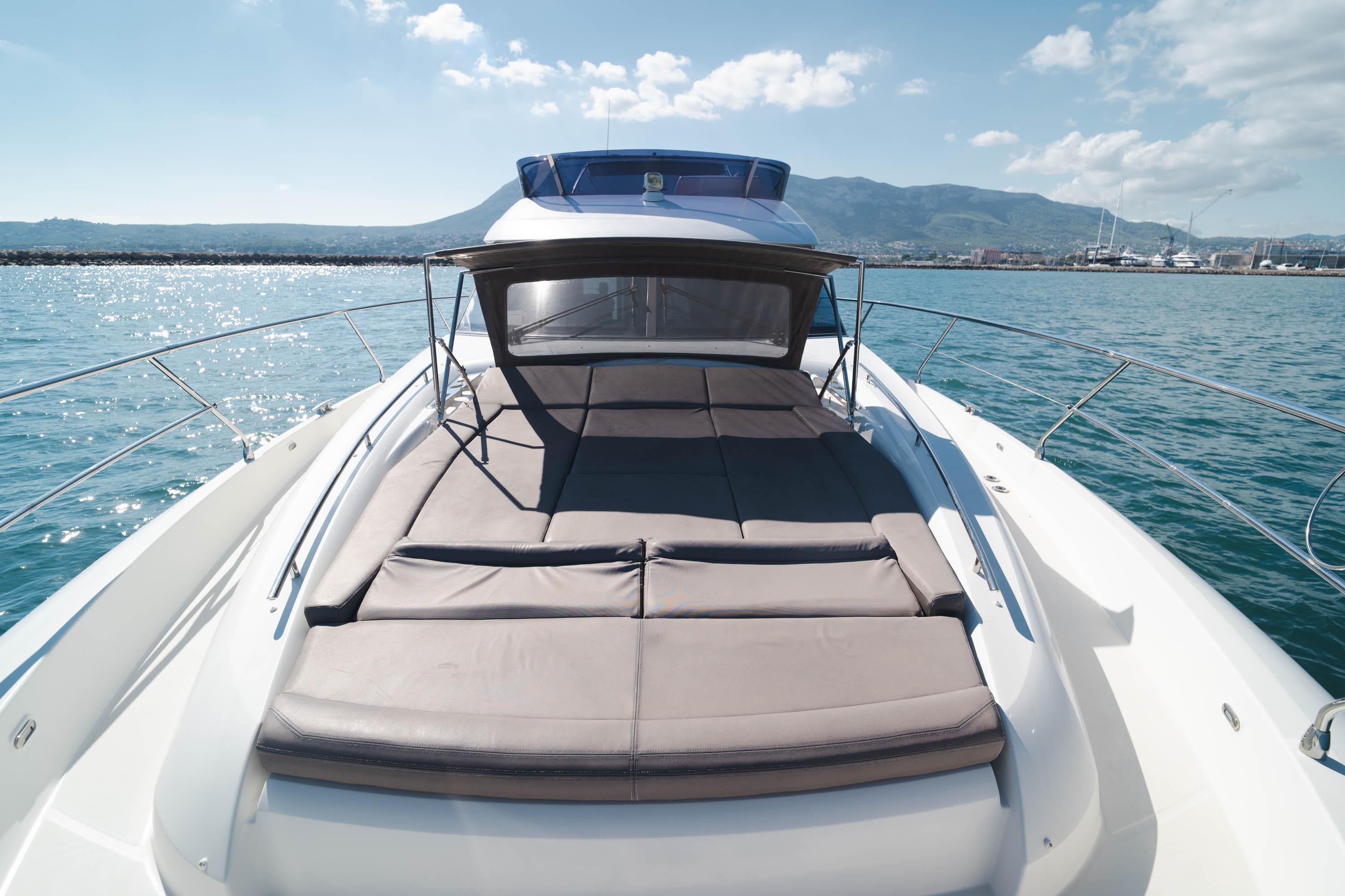 Luxury 2017 Prestige 560 yacht with sunbed, cruising on a sunny day.