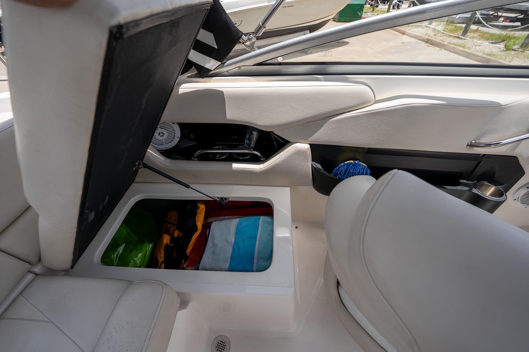 Interior storage compartment of a 2008 Regal 2000 Bowrider boat with various items inside.