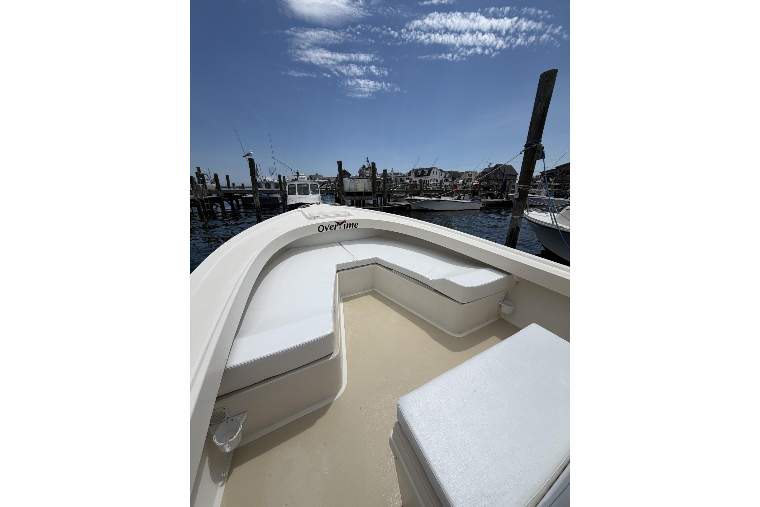 1999 Parker 2501 Center Console boat docked at marina under clear blue sky.