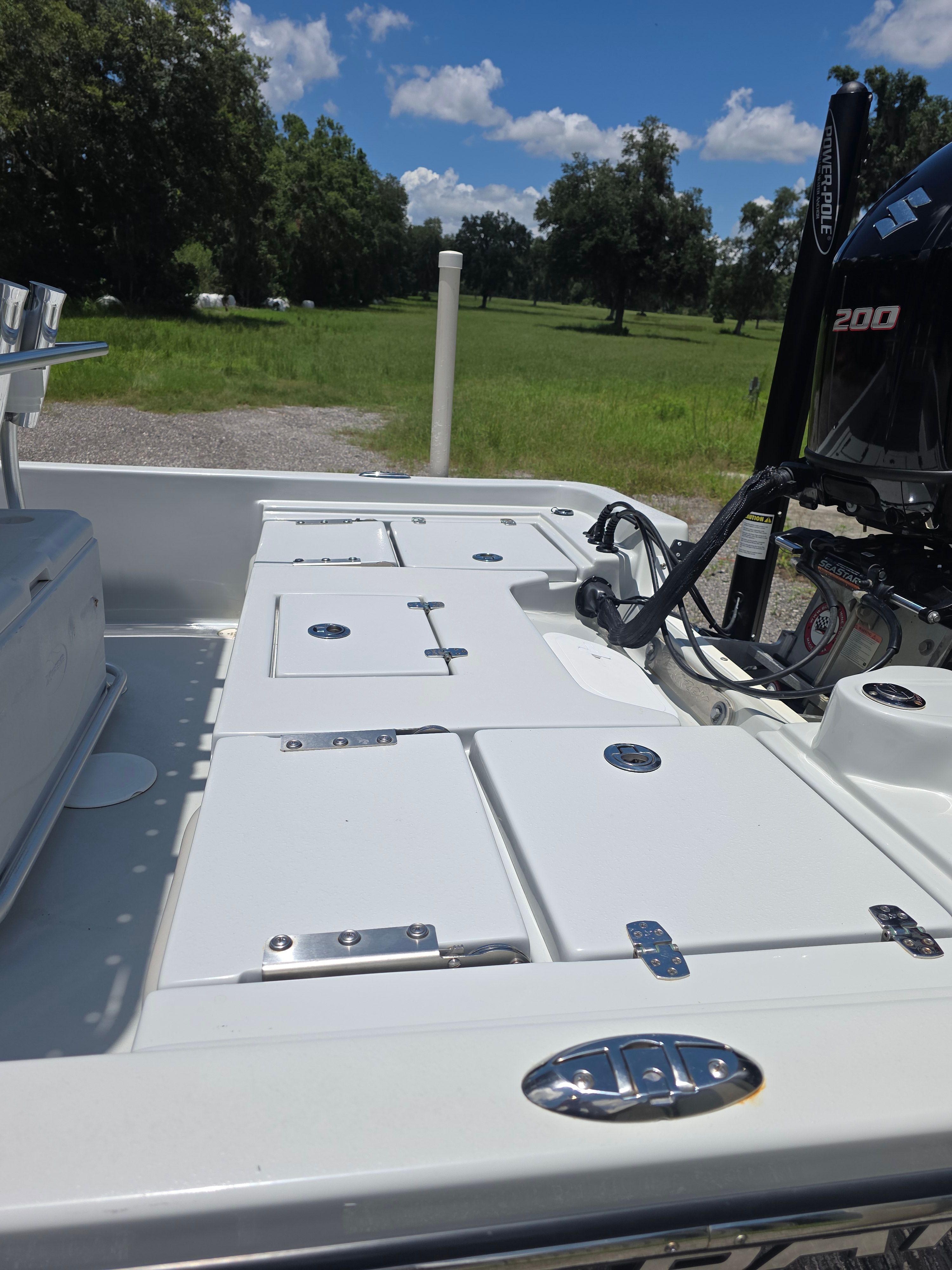 The image shows the deck of a 2019 Blazer Bay 2200 boat with storage compartments and an engine.