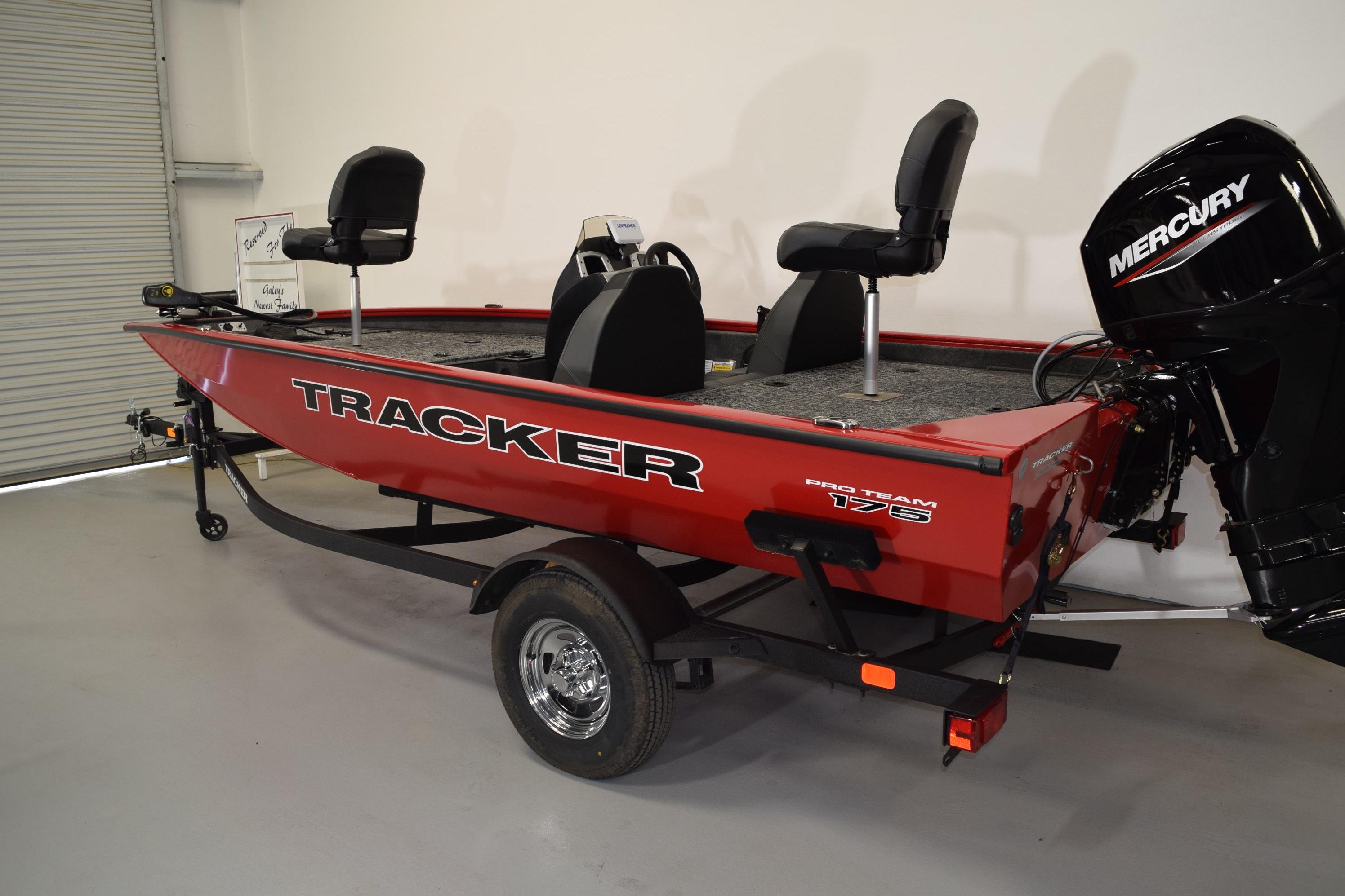 2026 Tracker Pro Team 175 boat with Mercury engine, red exterior, and trailer in showroom.