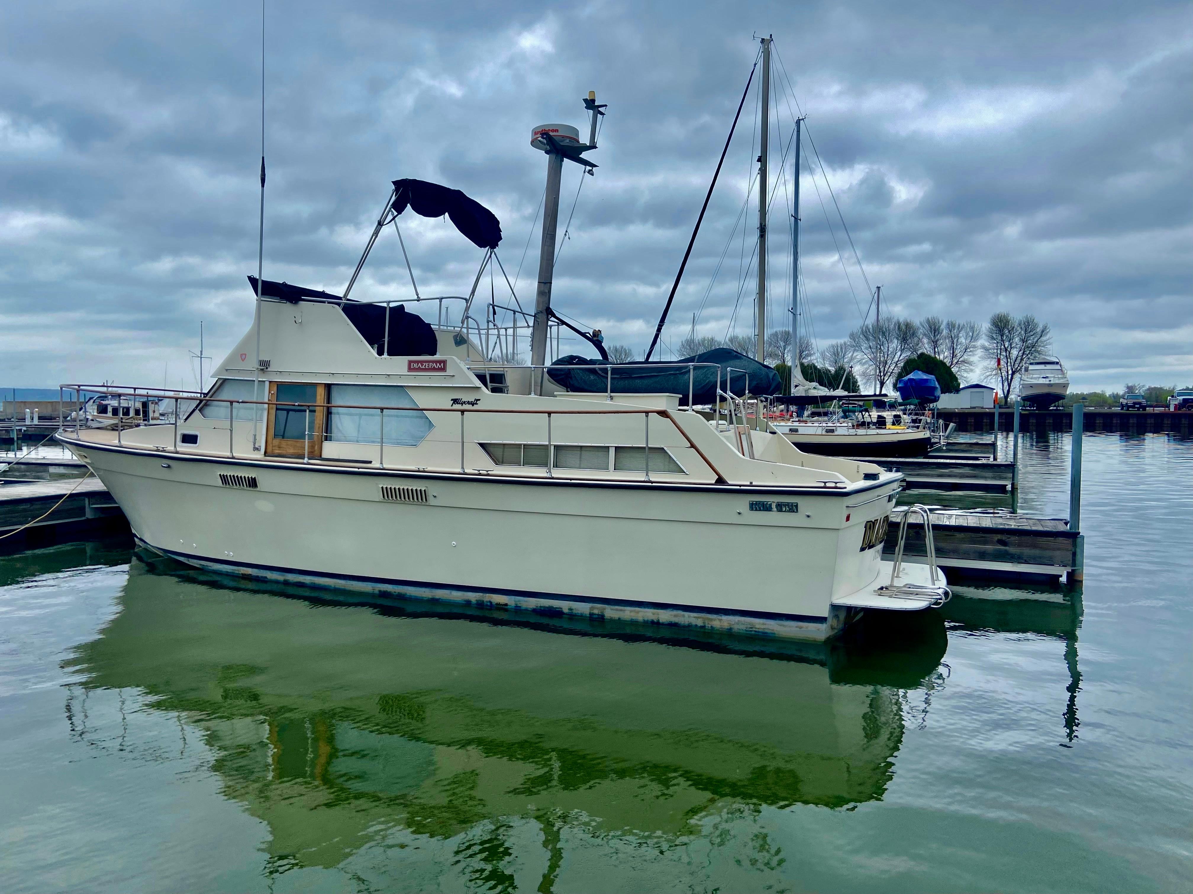1974 Tollycraft 40 Tri-Cabin Motoryacht docked at a marina under cloudy skies.