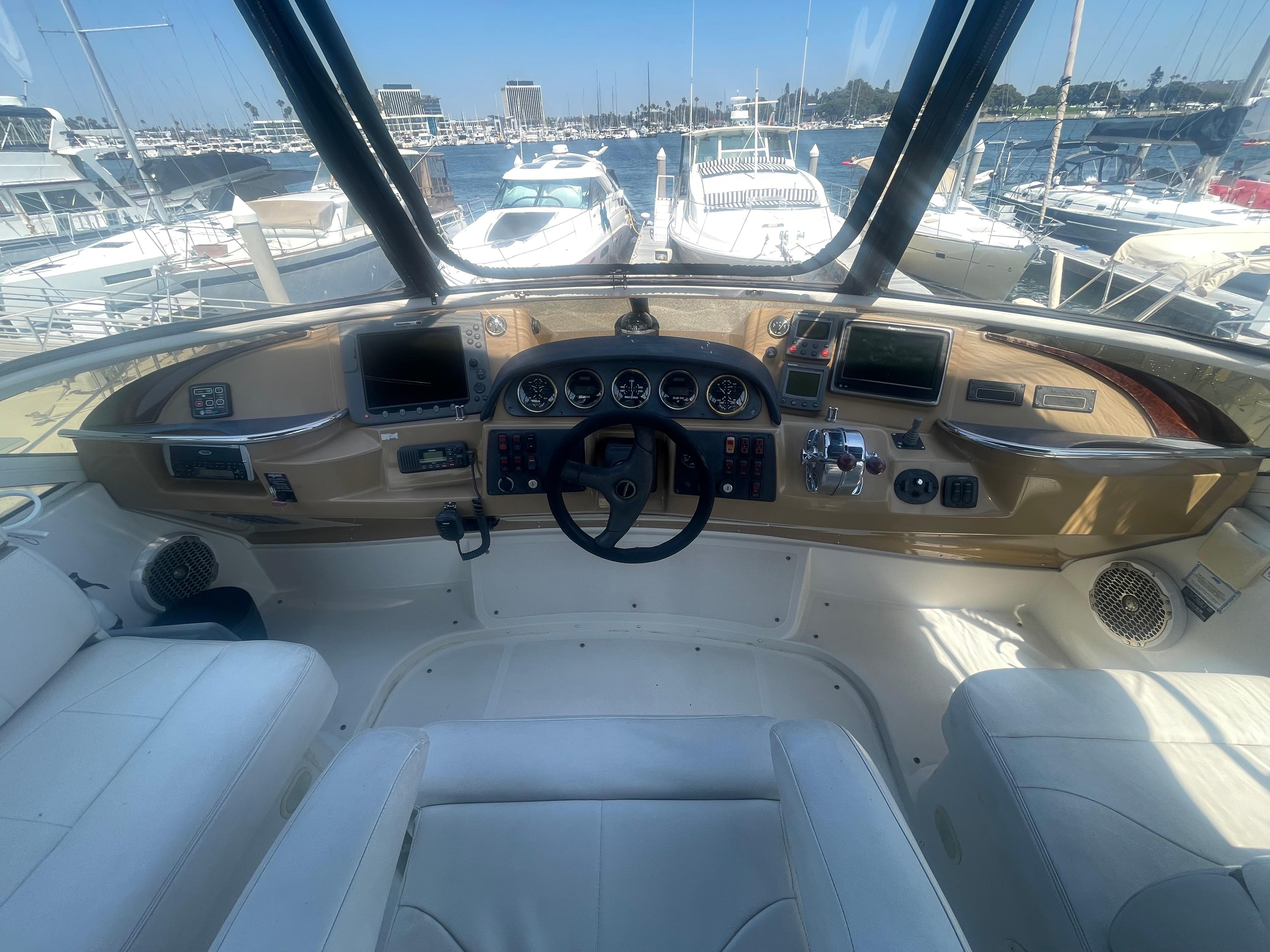 2004 Carver 44 Cockpit Motor Yacht helm with navigation instruments and marina view.