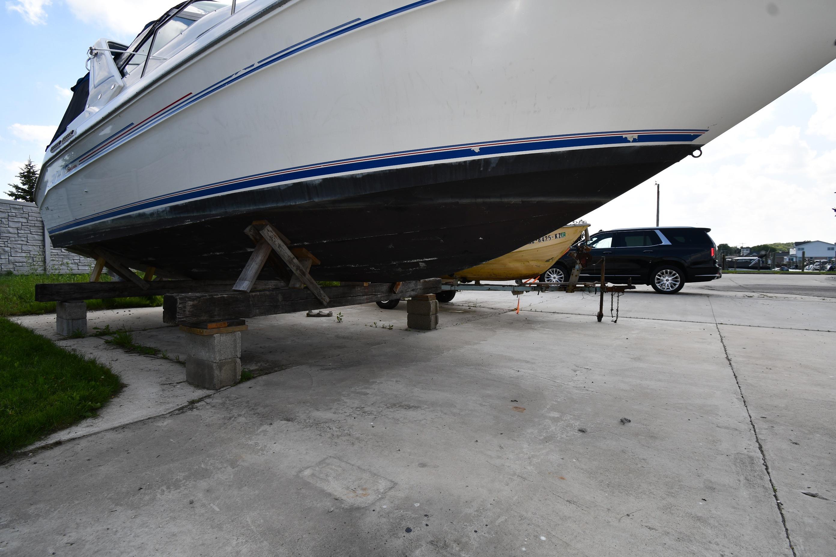 1993 Sea Ray 300 Sundancer boat on blocks in a parking area.
