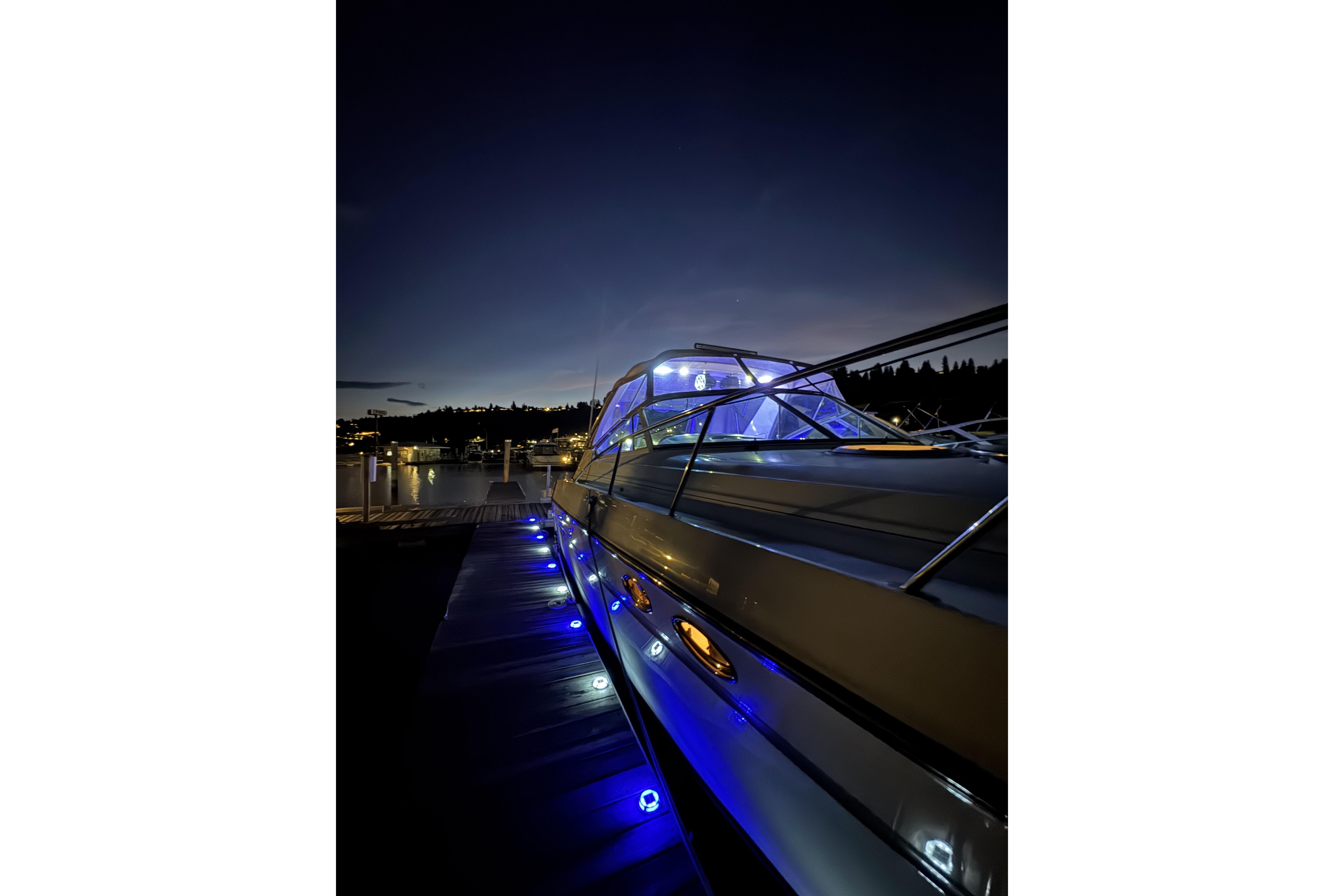 1998 Maxum 4100 SCR yacht illuminated with blue lights at night, docked at marina.
