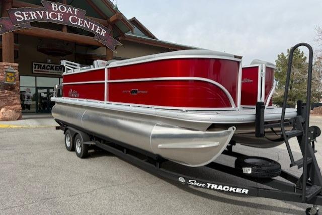 2026 Sun Tracker Party Barge 22 DLX pontoon boat on trailer at service center.