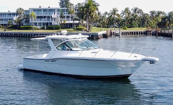 2006 Tiara Yachts 3200 Open cruising on a calm waterfront with palm trees.
