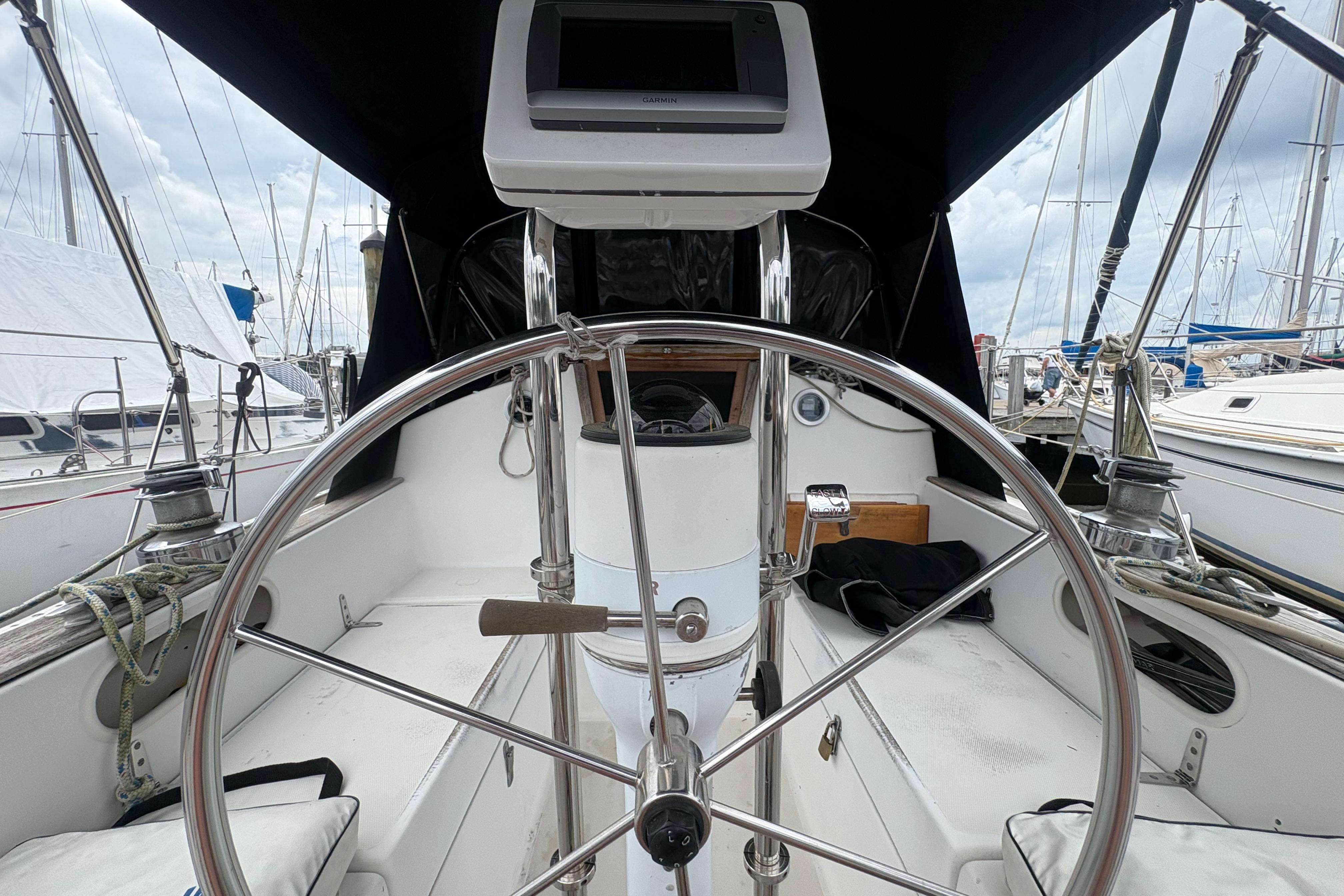 1981 Sabre 31 sailboat cockpit with steering wheel, docked at marina.