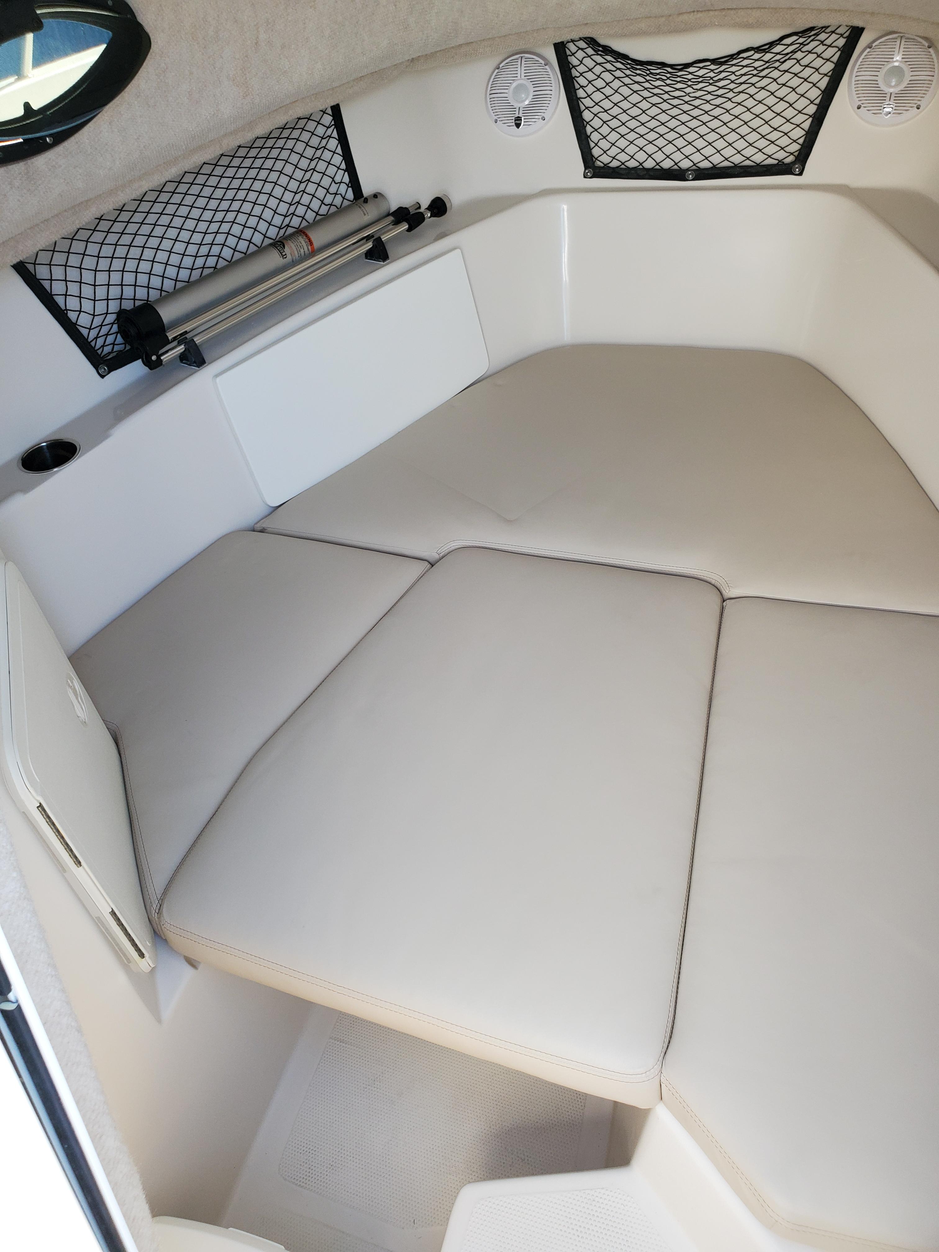 2022 Sailfish 220 WAC cabin interior with cushioned seating and storage nets.