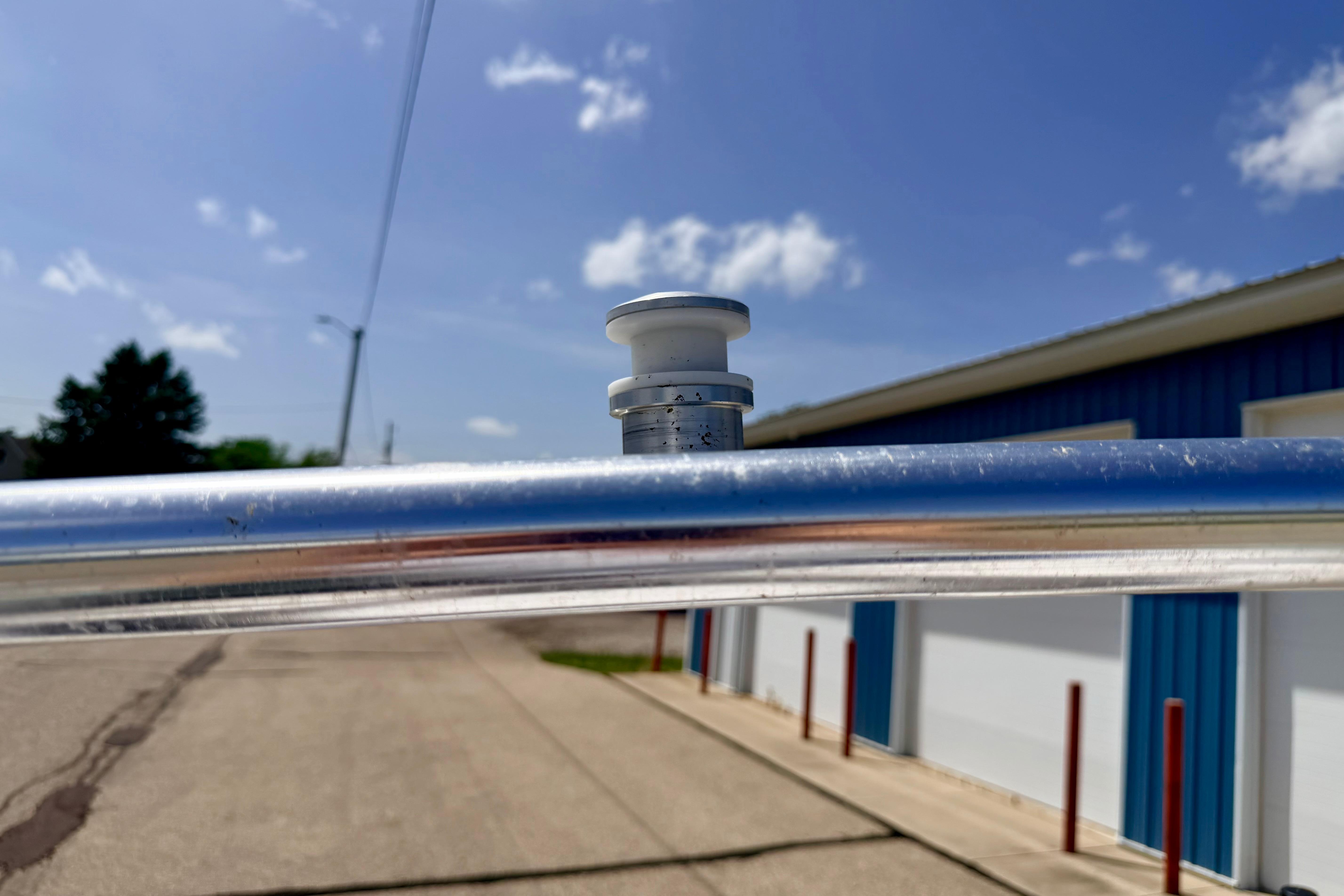 Close-up of a 2008 Moomba Outback V boat's metal railing under a clear blue sky.