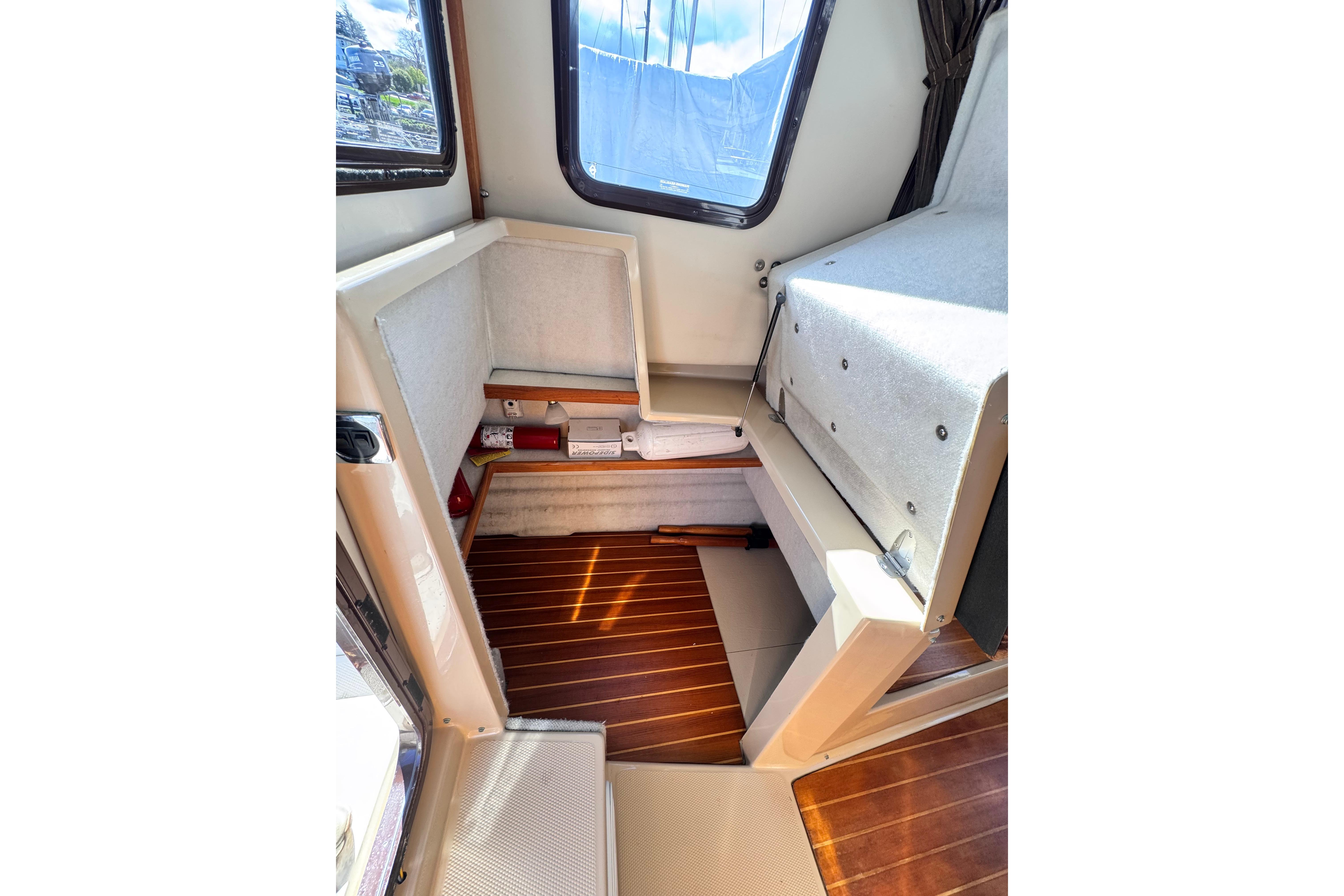 Interior of 2011 Ranger Tugs R-25 boat, featuring wooden flooring and seating area.