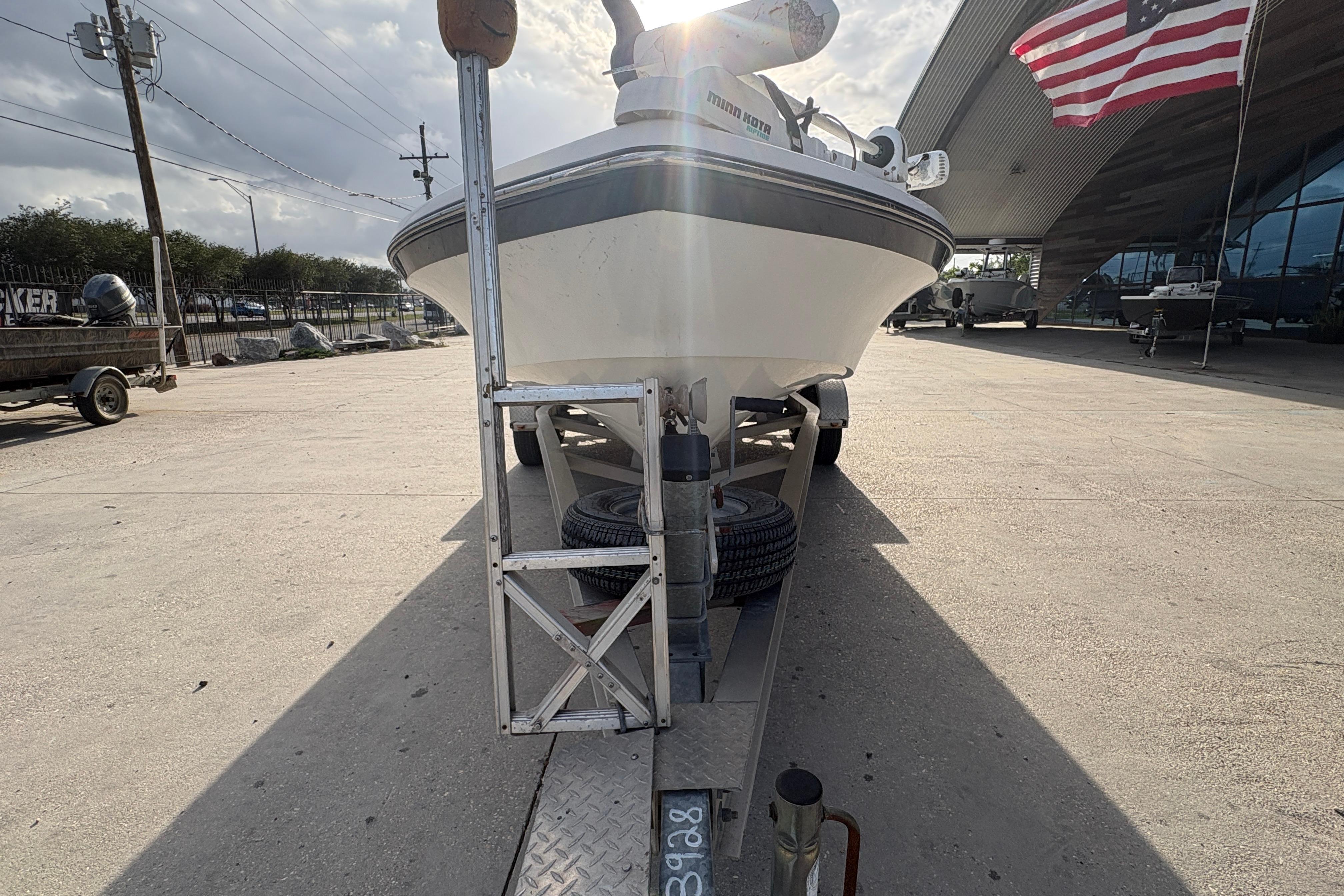 2012 BlackJack 224 boat on trailer, parked outdoors with American flag in background.