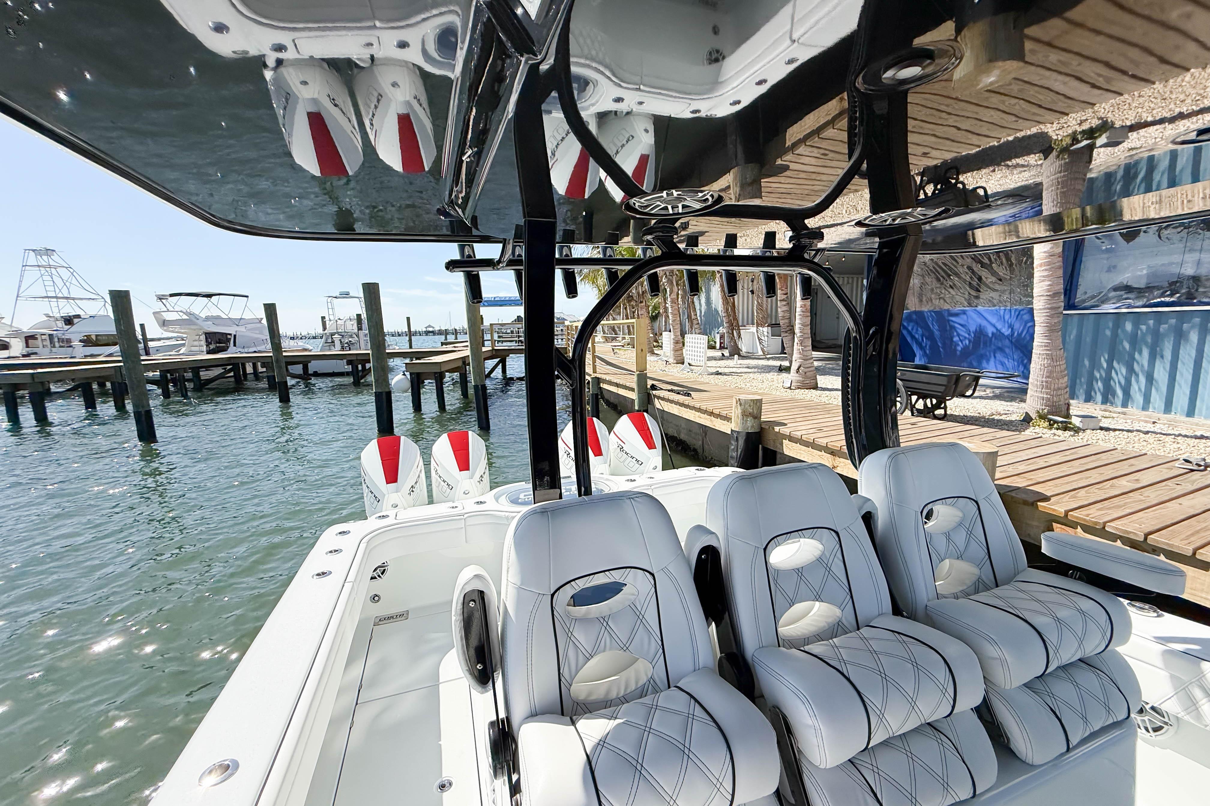 2023 Costa Custom Boats 34 model with luxurious seating at a marina dock.