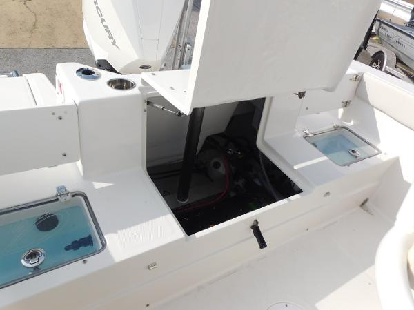 2025 Sailfish 232 CC boat interior with open storage compartments and visible engine components.