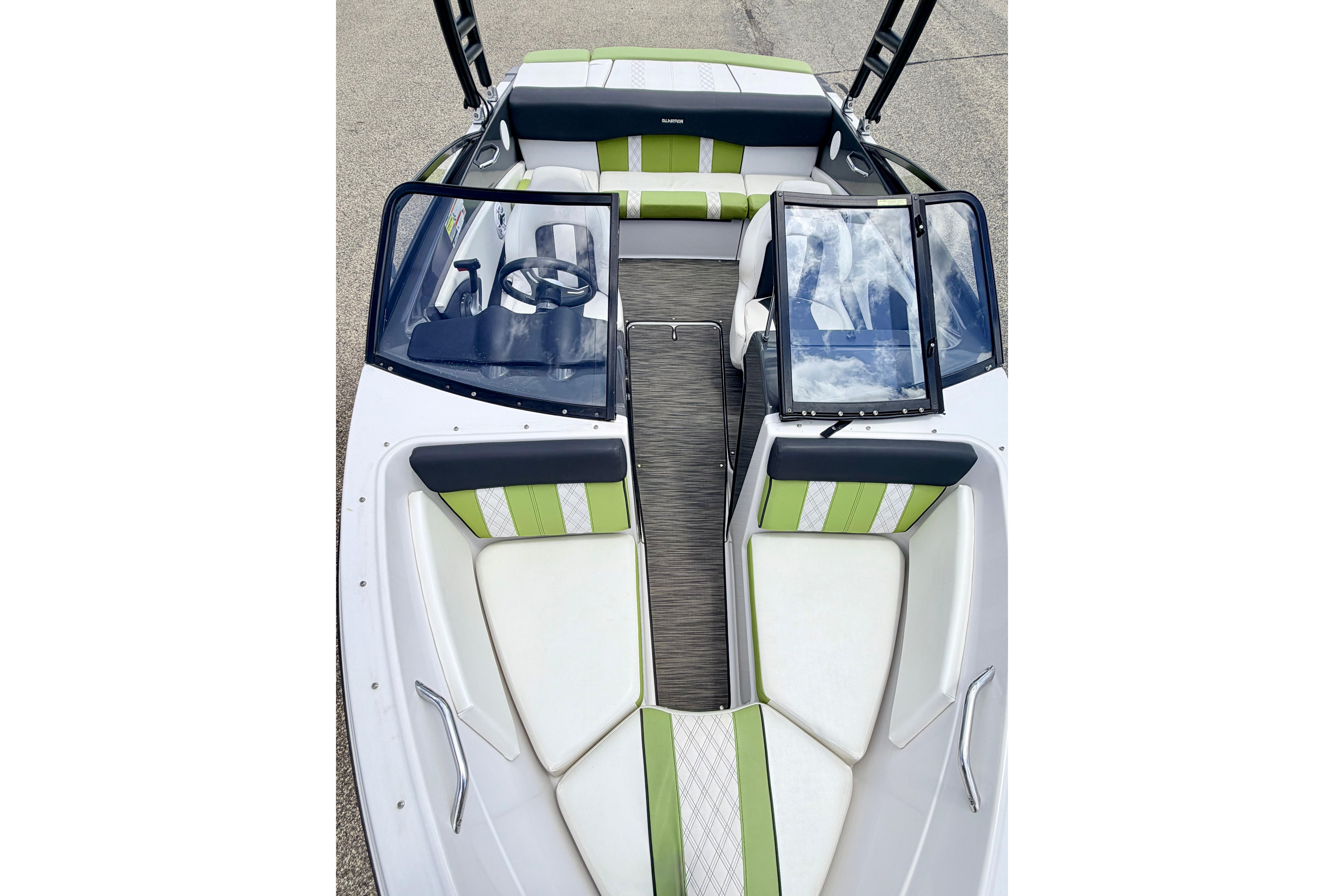 2018 Glastron GT 185 boat interior with green and white seating, open windshield, and steering wheel.
