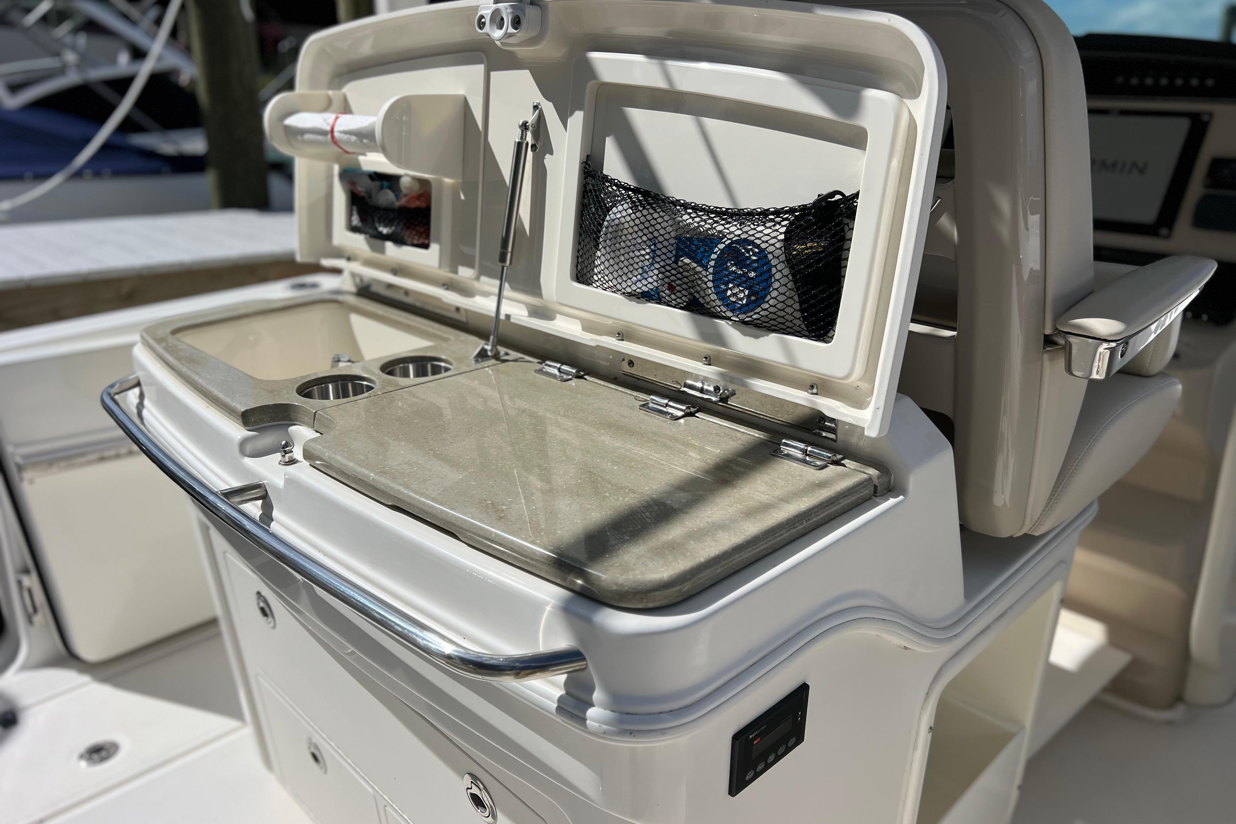 2021 Boston Whaler 330 Outrage boat interior with open storage compartment and cup holders.