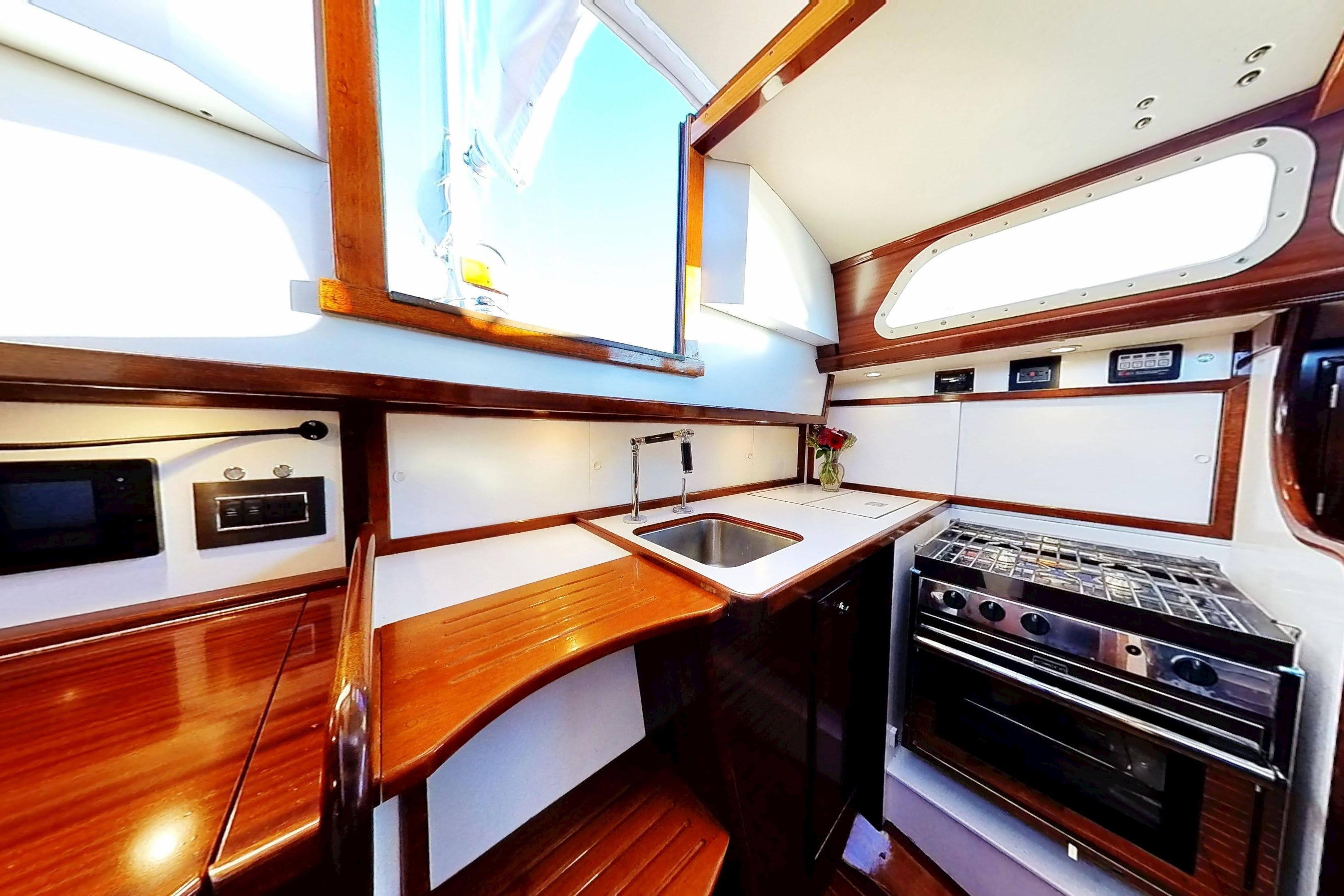 Interior of 1970 Hinckley Bermuda 40 yacht kitchen with wood finish and modern appliances.