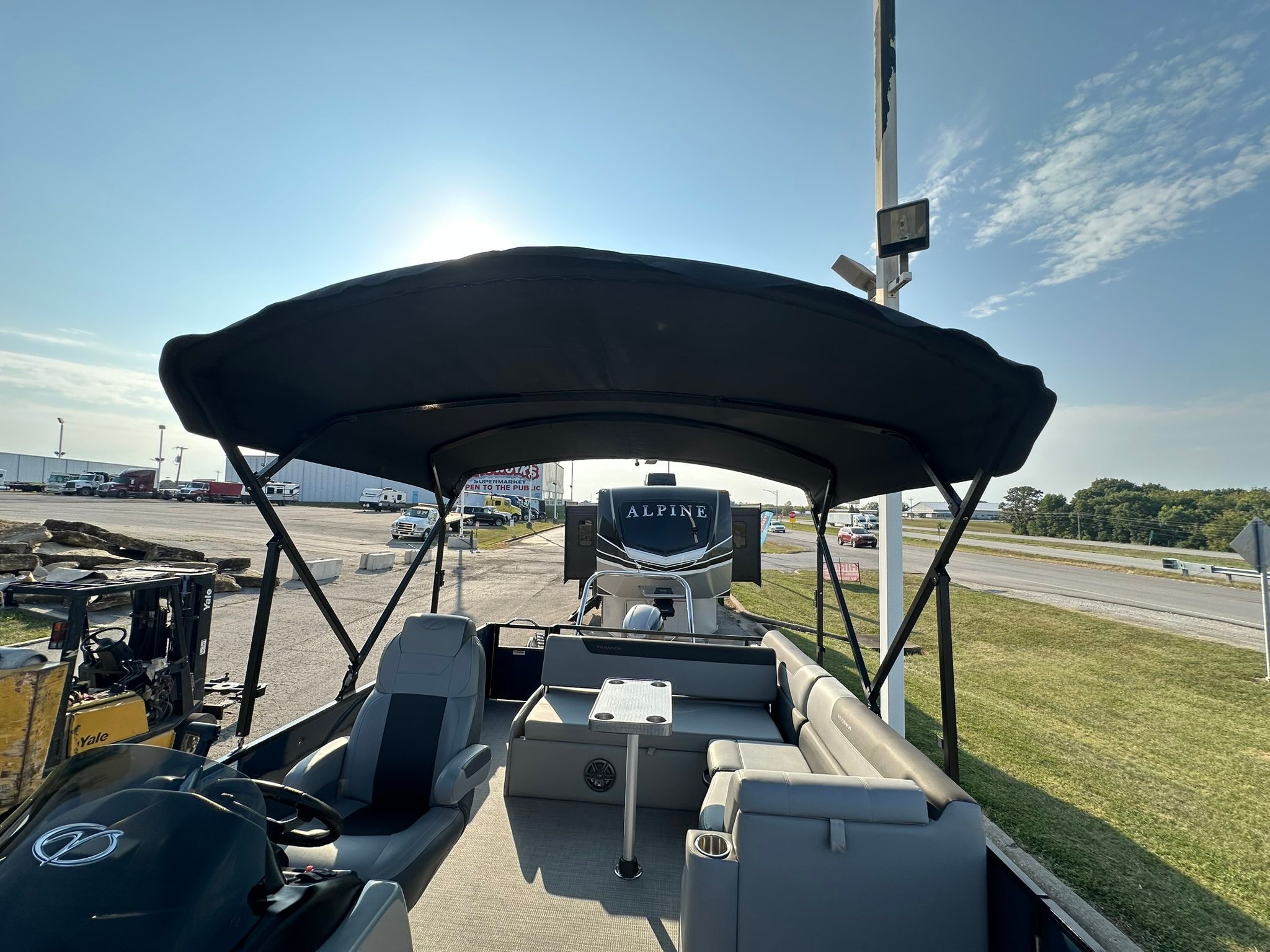 2023 Veranda Relax VR25VLB pontoon boat with canopy on parking lot.