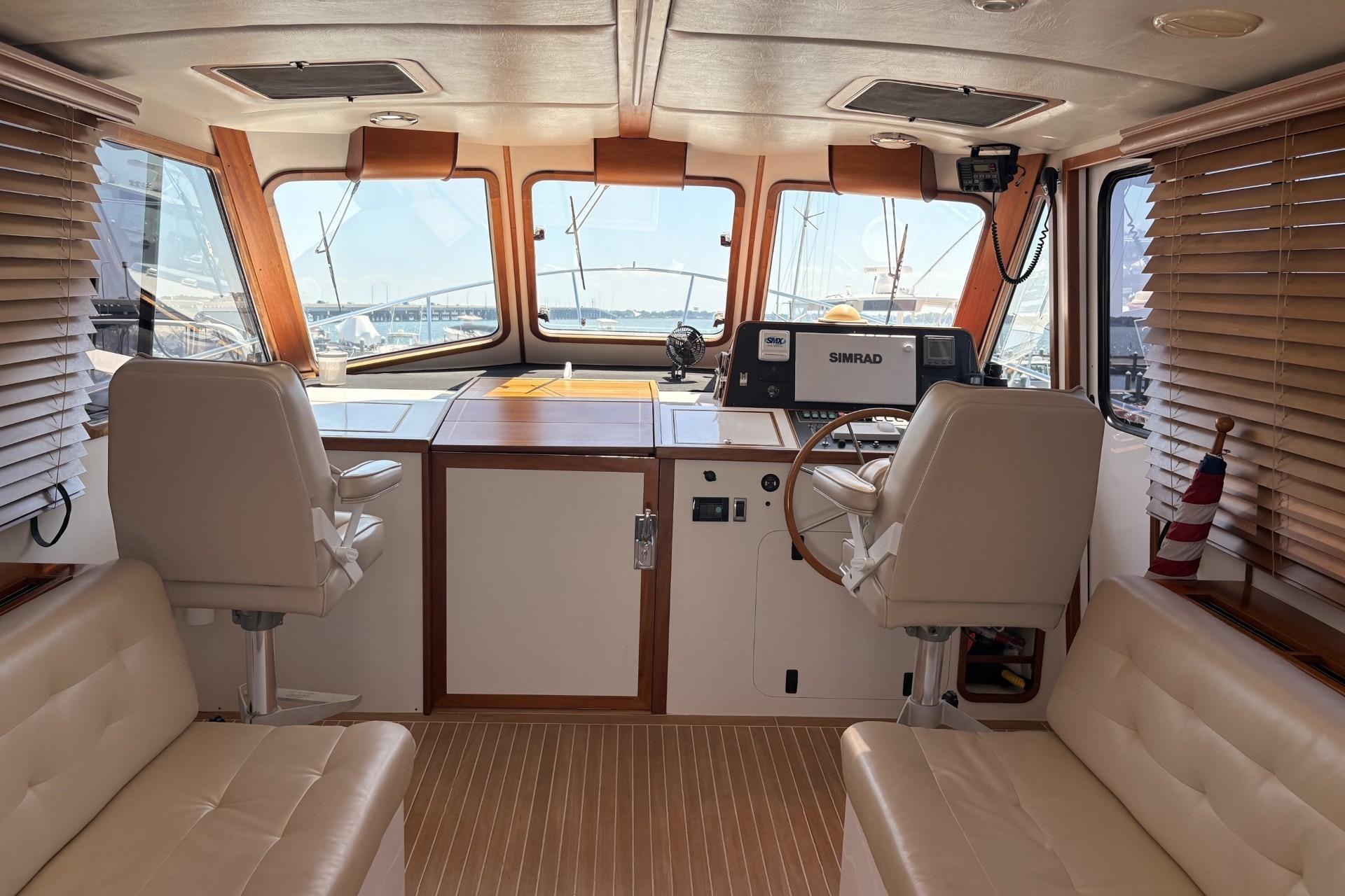 Luxurious boat interior with leather seating, wooden accents, and advanced navigation equipment.