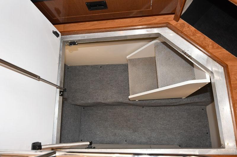 Storage compartment in 2008 Carver 43 Super Sport yacht, featuring carpeted interior and wooden trim.