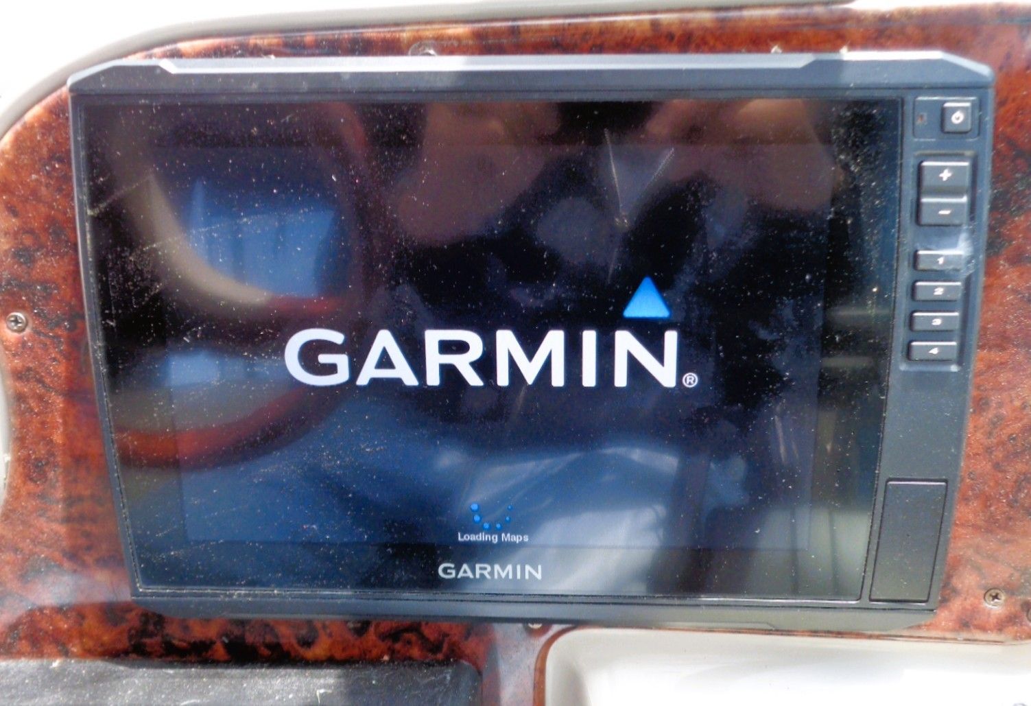 Garmin navigation device on a boat with wood paneling.