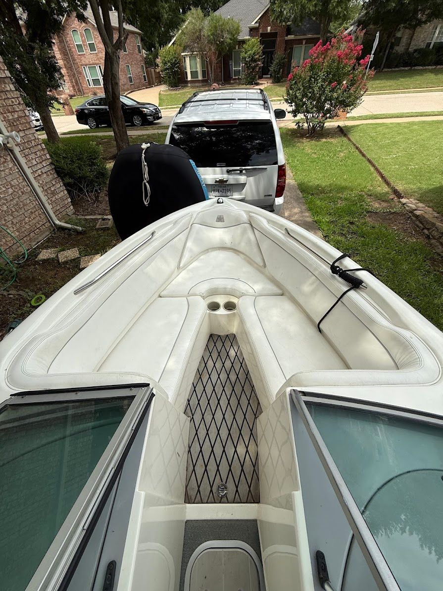 The image shows the bow of a 1999 MasterCraft Prostar 205 boat parked in a driveway.