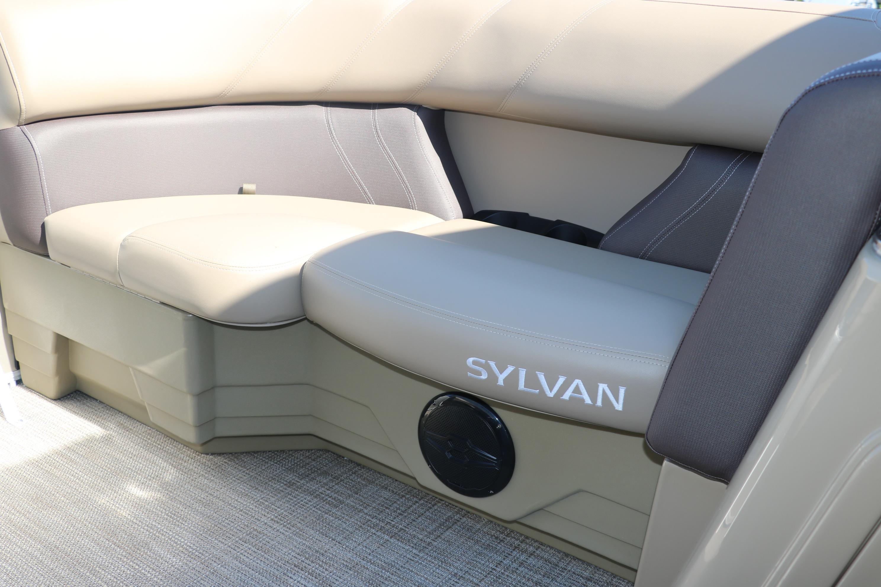 2025 Sylvan Mirage 820 CLZ DH boat interior with beige seating and speaker.