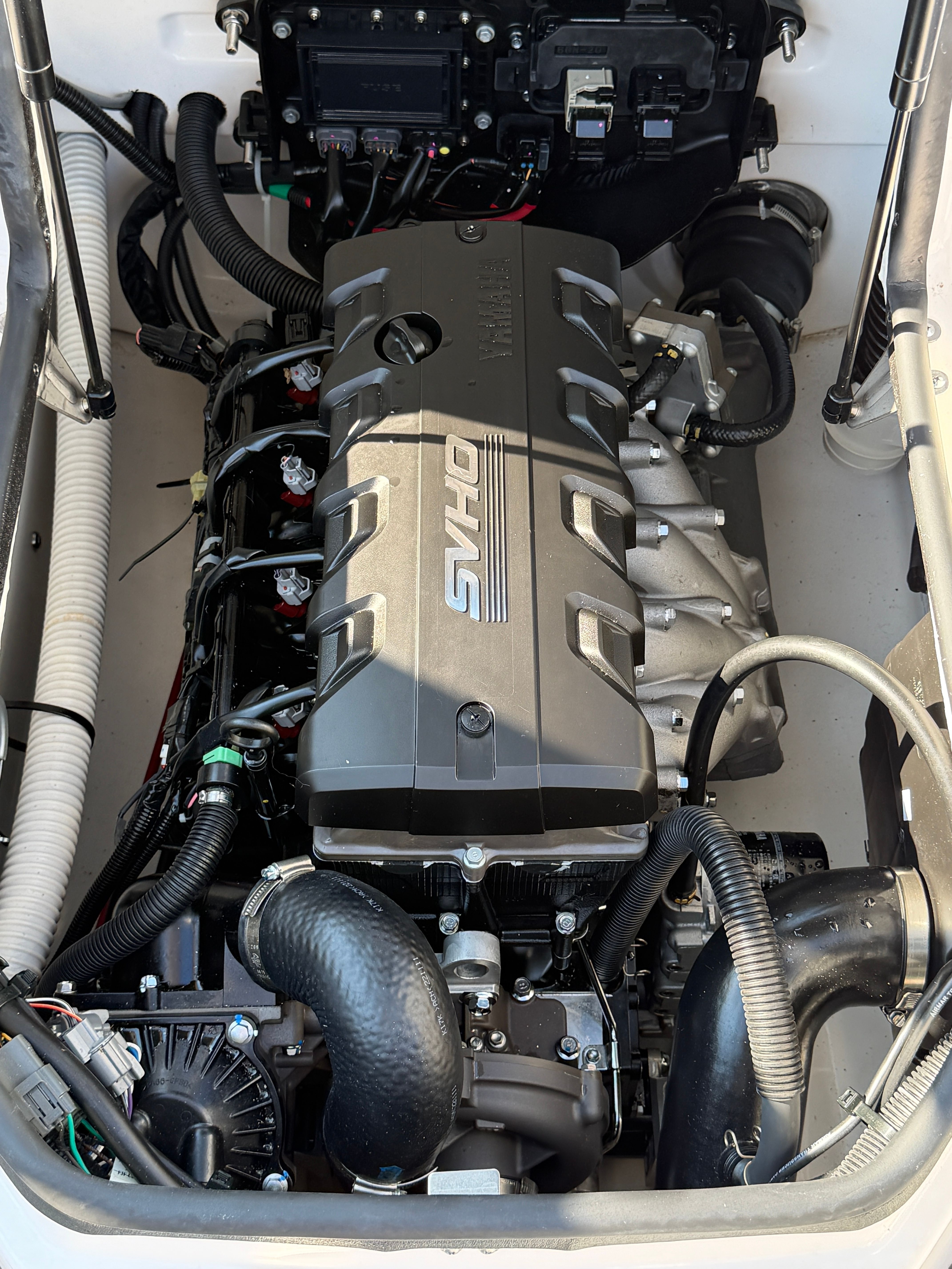 Engine compartment of a Yamaha 195S boat featuring a powerful SVHO engine with various hoses and cables.