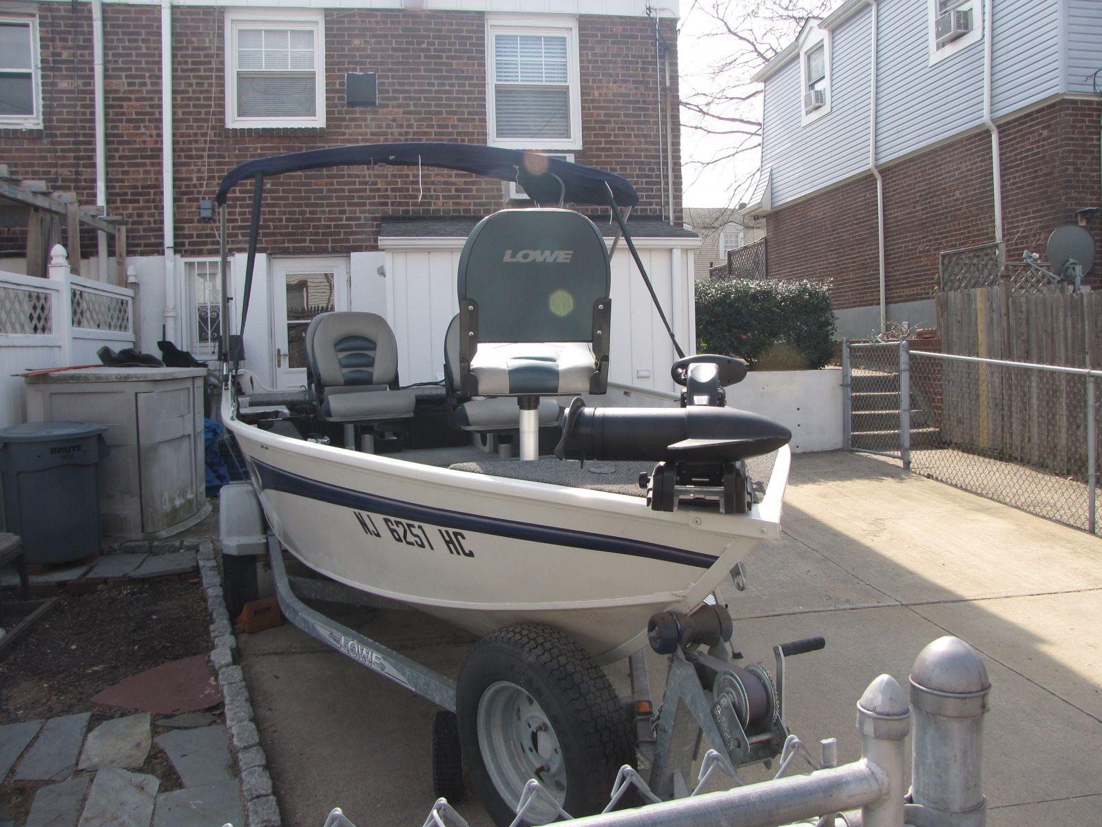 A Lowe Angler 160T boat is on a trailer in a driveway.