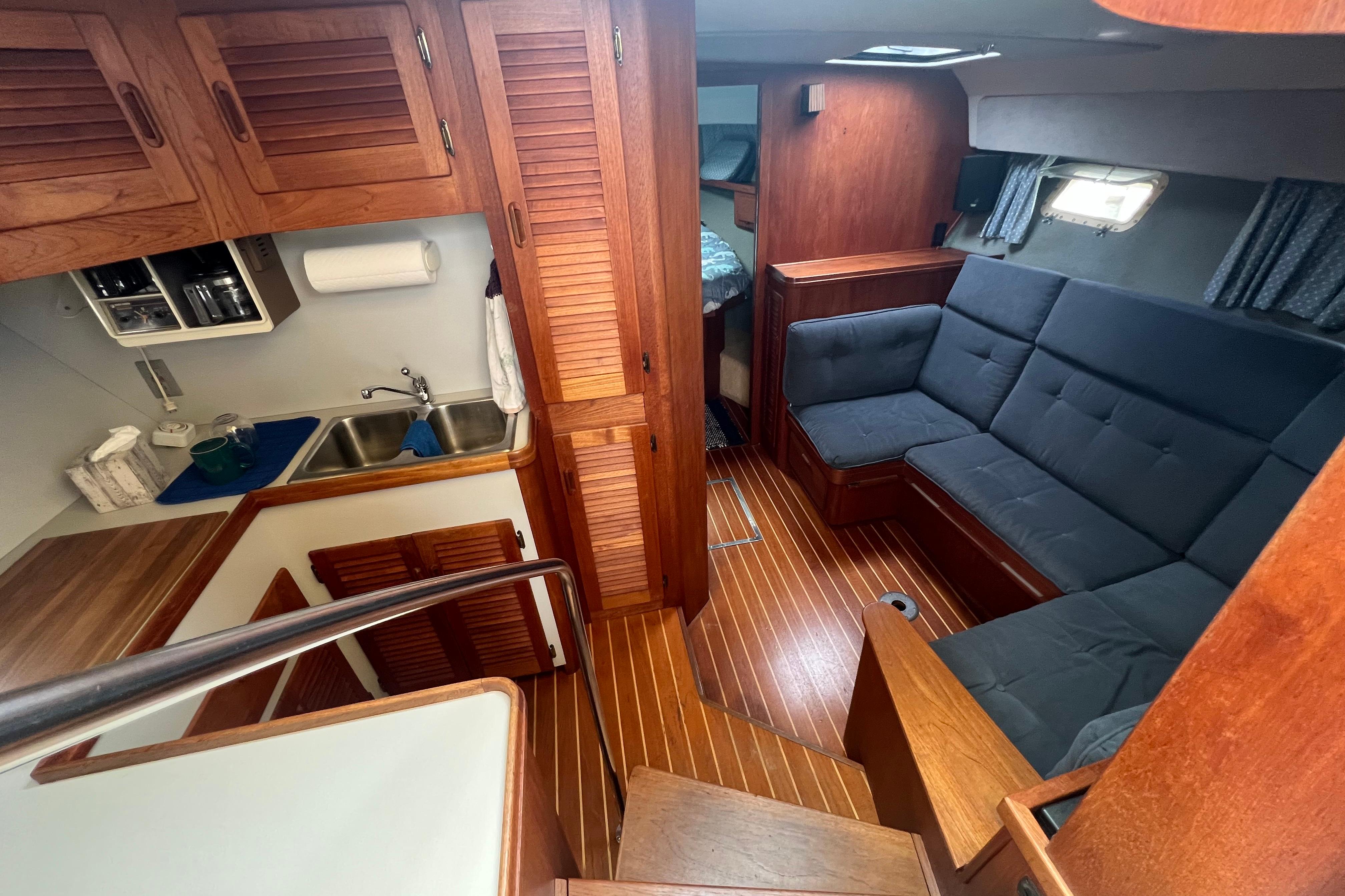Interior of 1985 Tiara 36 OPEN yacht with wooden cabinetry and cozy seating area.