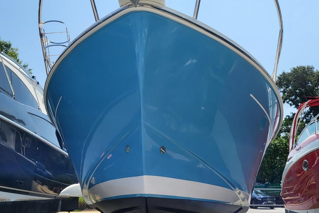 2006 Back Cove 29 boat with blue hull, docked between other vessels.