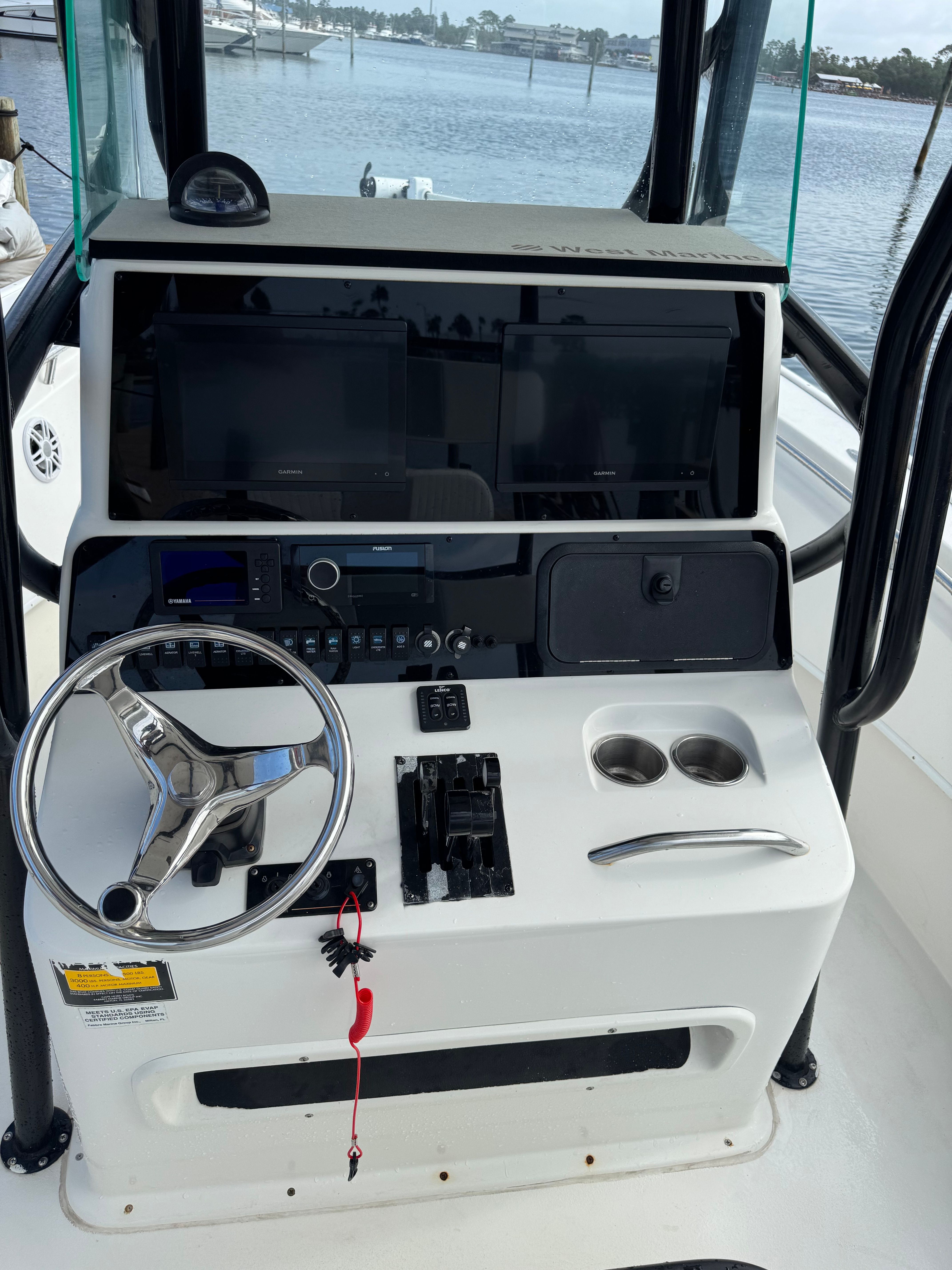 The image shows the helm of a 2014 Cape Horn 24XS boat with steering wheel and instruments.