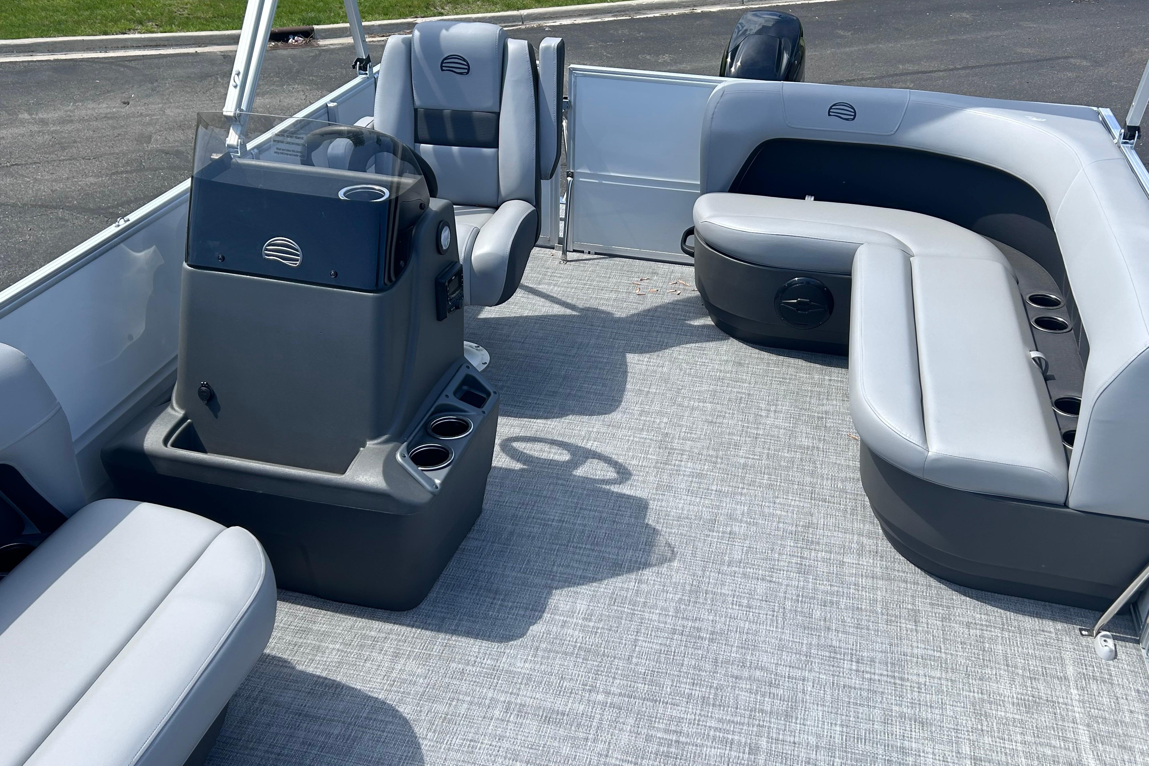 2026 Sun Tracker Party Barge 16 DLX interior with gray seating and steering console.